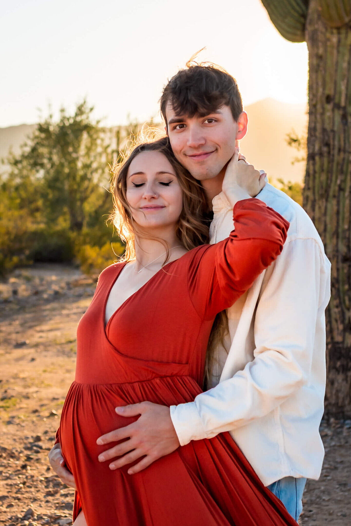 Beautiful mom-to-be leaning against husband for comfort. Photographed by Cactus & Pine Photography