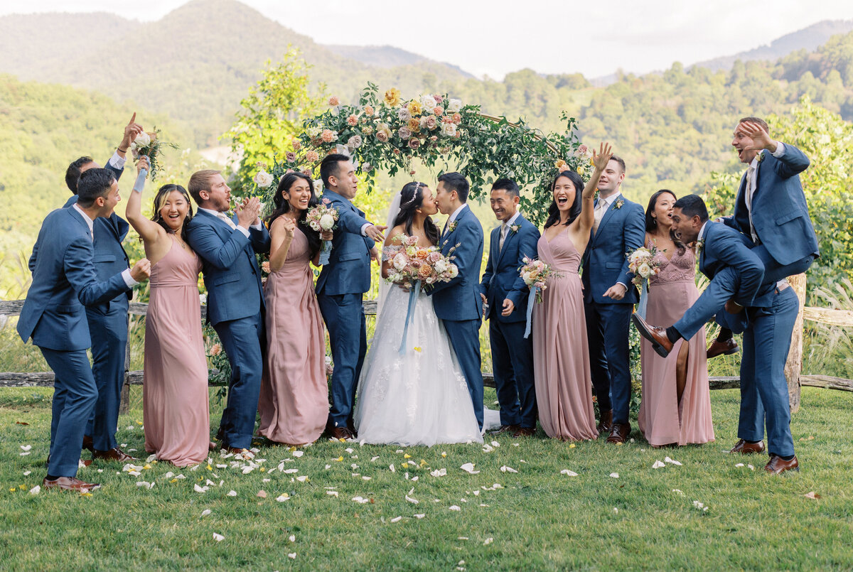 Wedding party celebrating outdoors with mountain views and floral arch backdrop at Castle Ladyhawke in North Carolina.