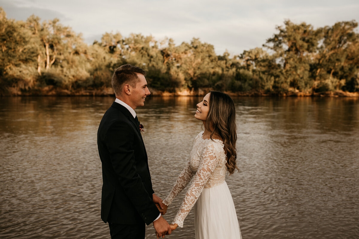 bride and groom holding hands in the Rio Grande