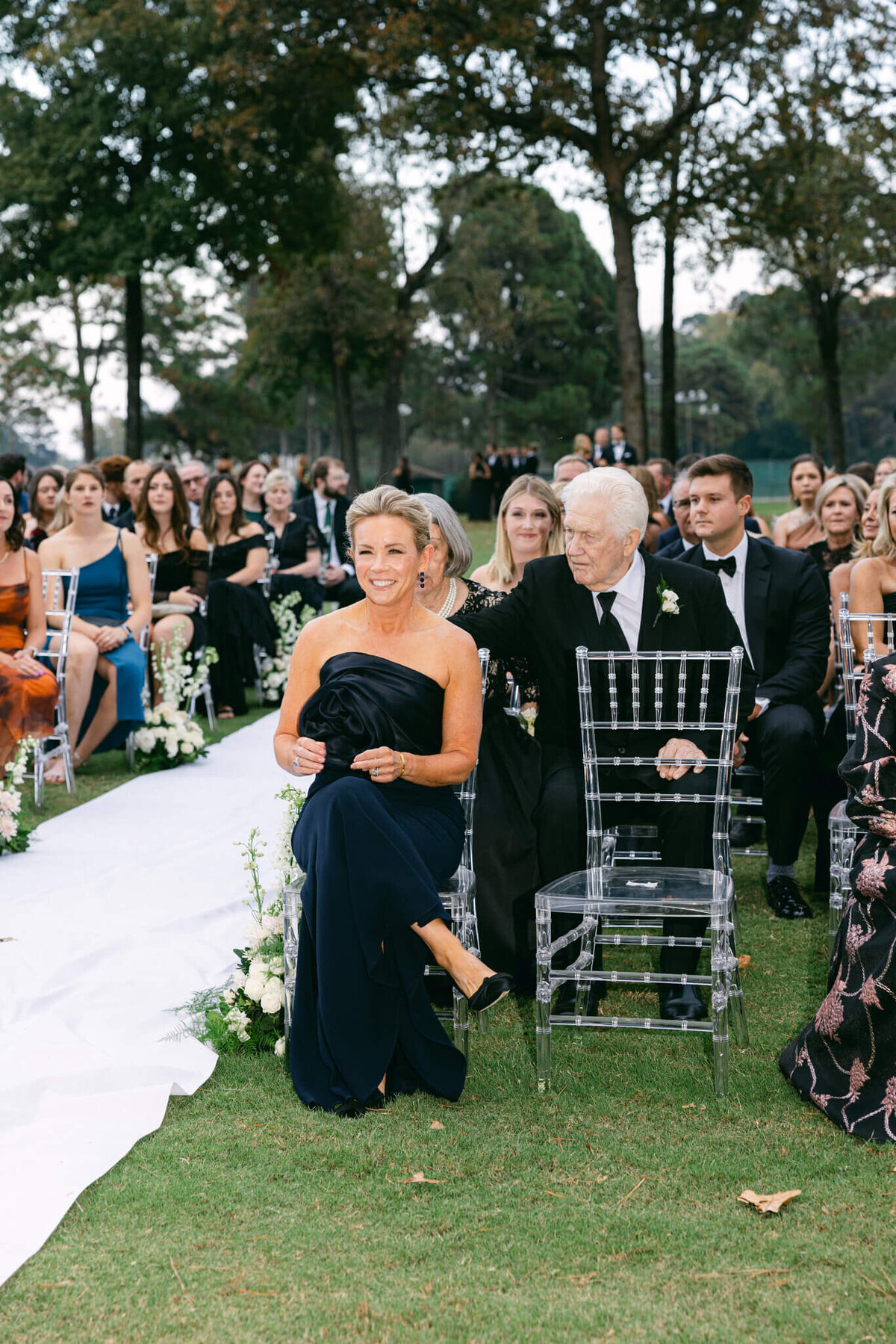 A wedding photo of the brides mom sitting at the ceremony excited