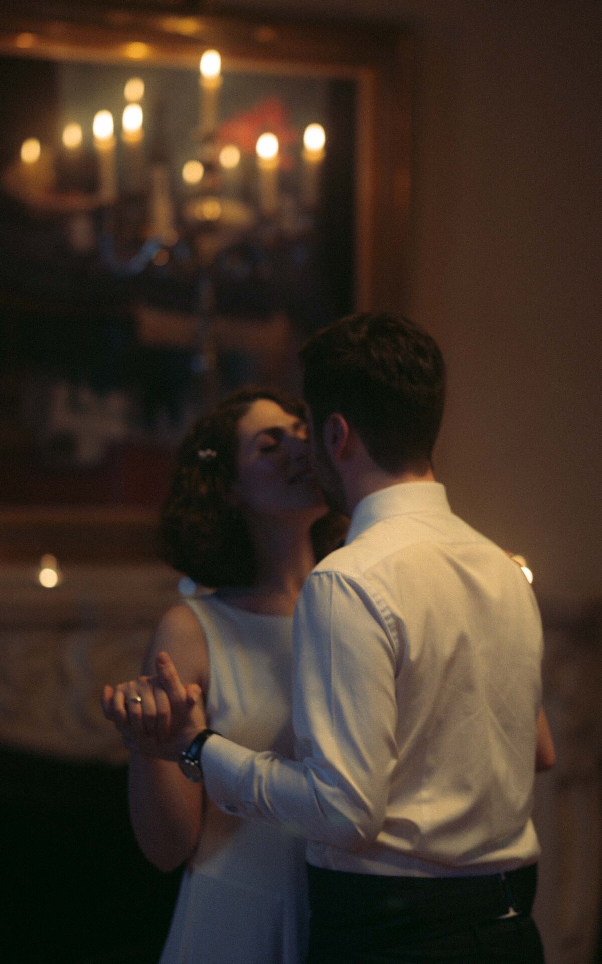 Enchanting moments captured as the newlyweds share a slow dance during their wedding reception, surrounded by love, laughter, and celebration