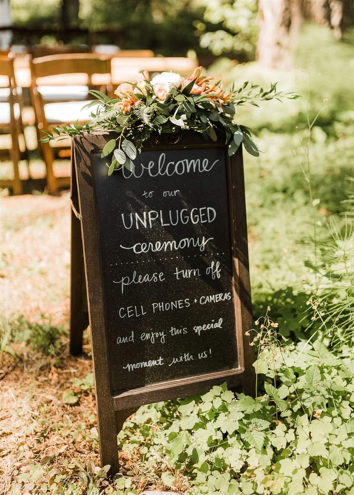 Floral arrangement atop a wedding  ceremony sign.