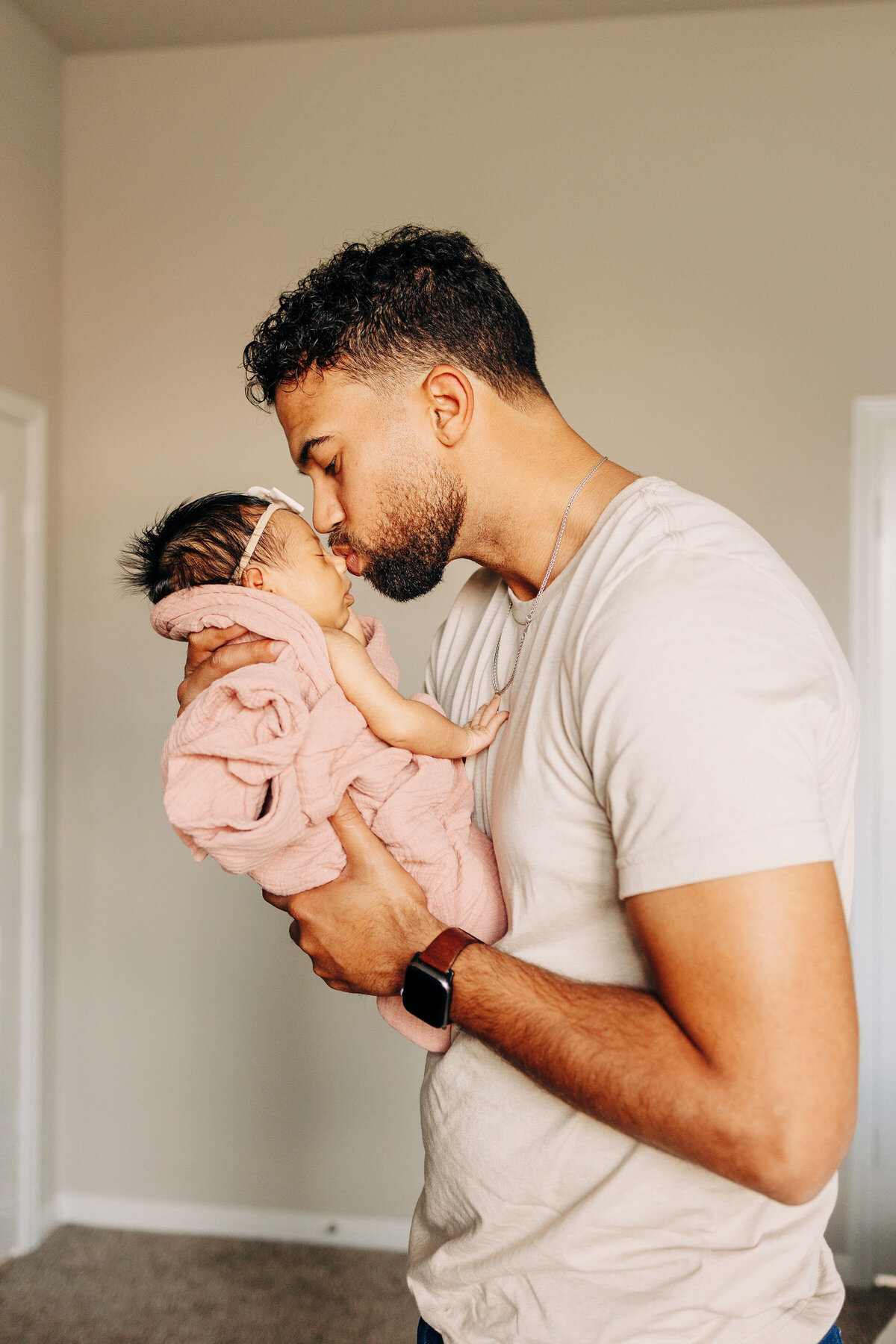 baby being kissed by dad during newborn photography session