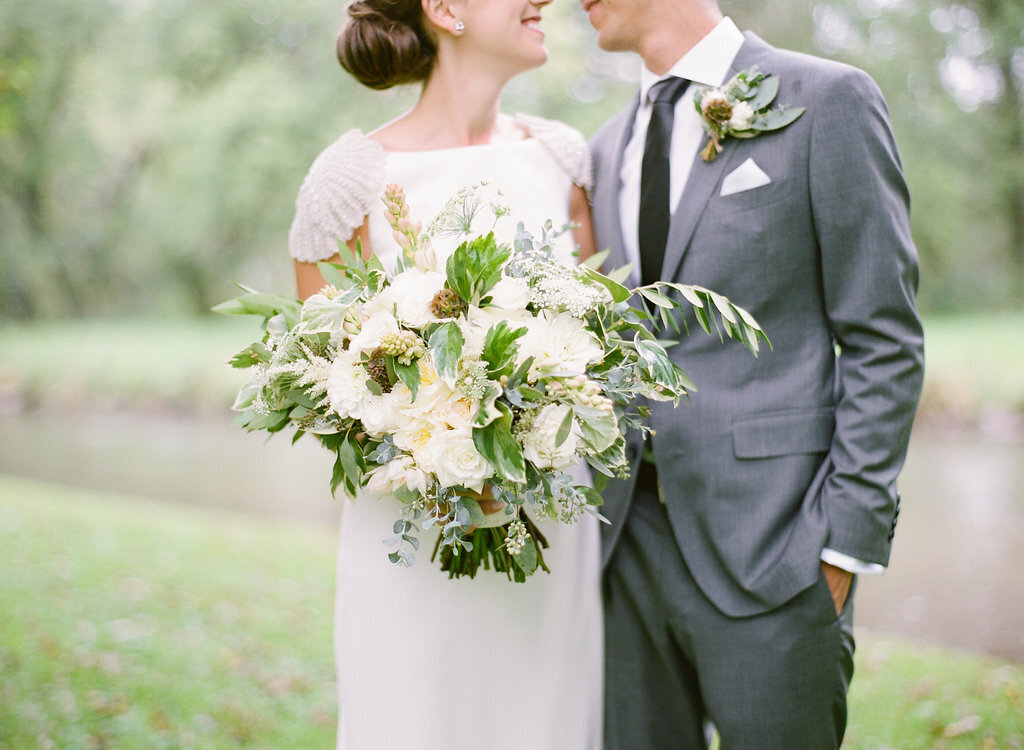 Bride and groom portrait, holding bouquet Green and white themed wedding