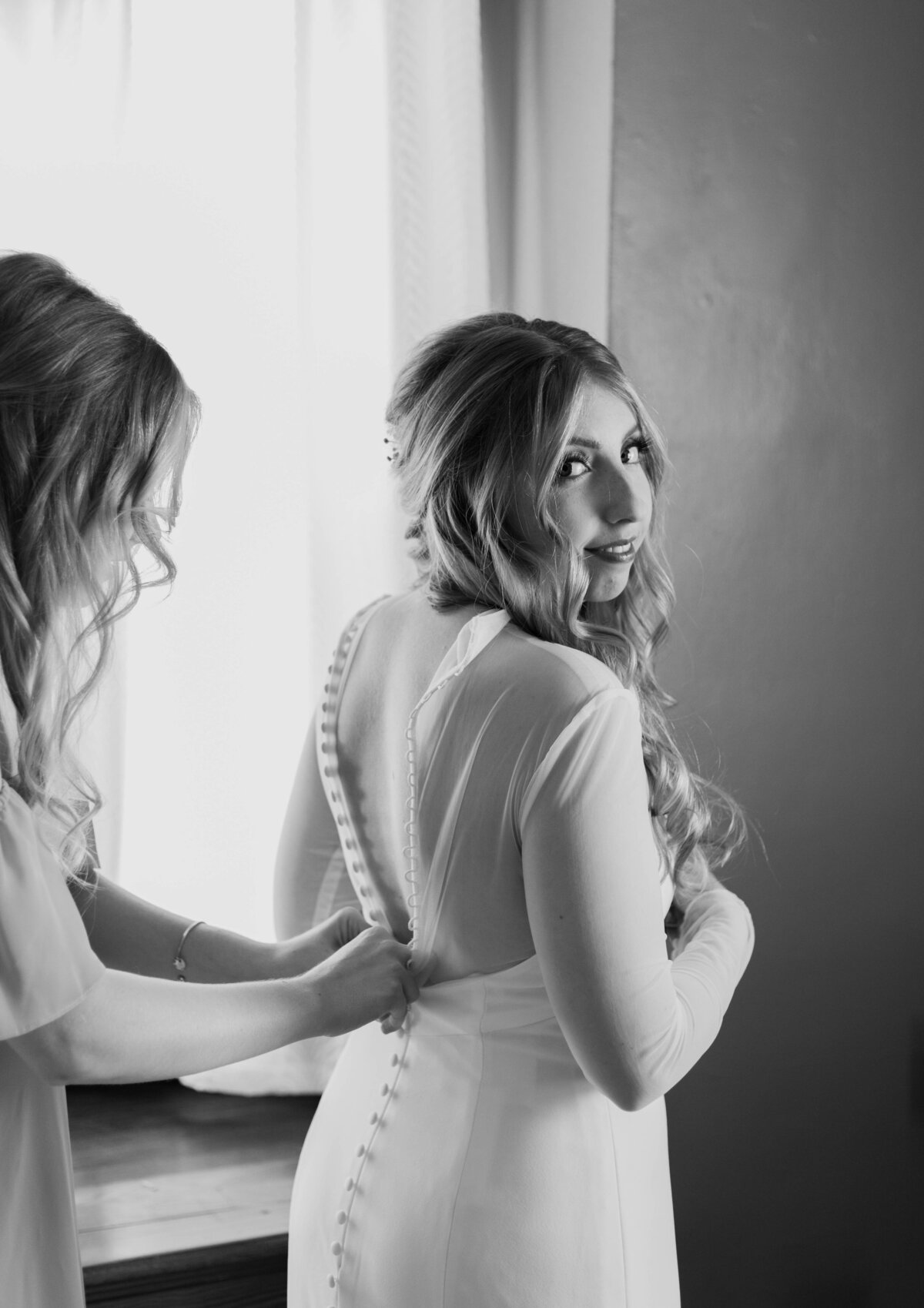bride getting dress buttoned
