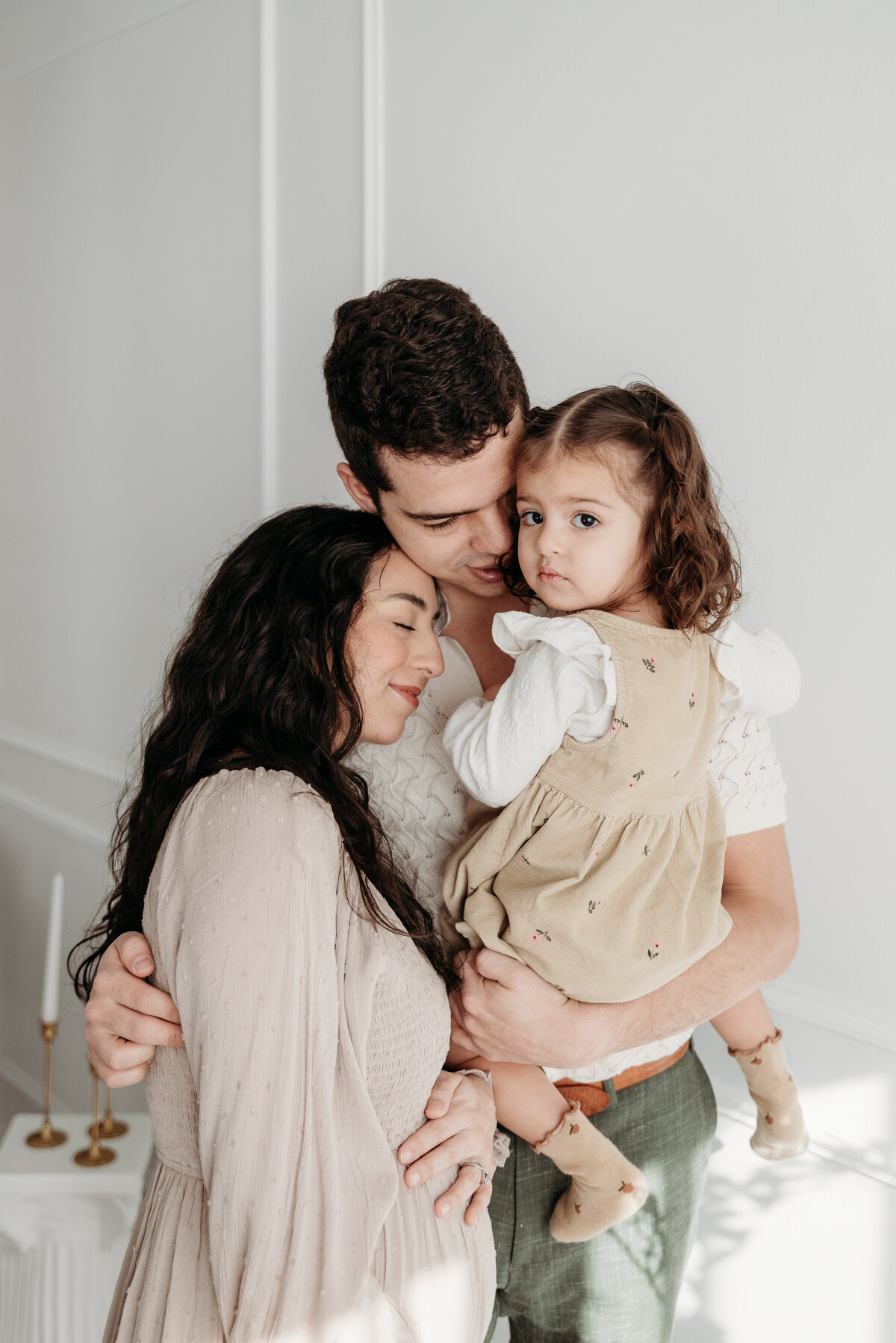 Family of 3 cuddled up during a studio maternity photoshoot, Bartlett, IL