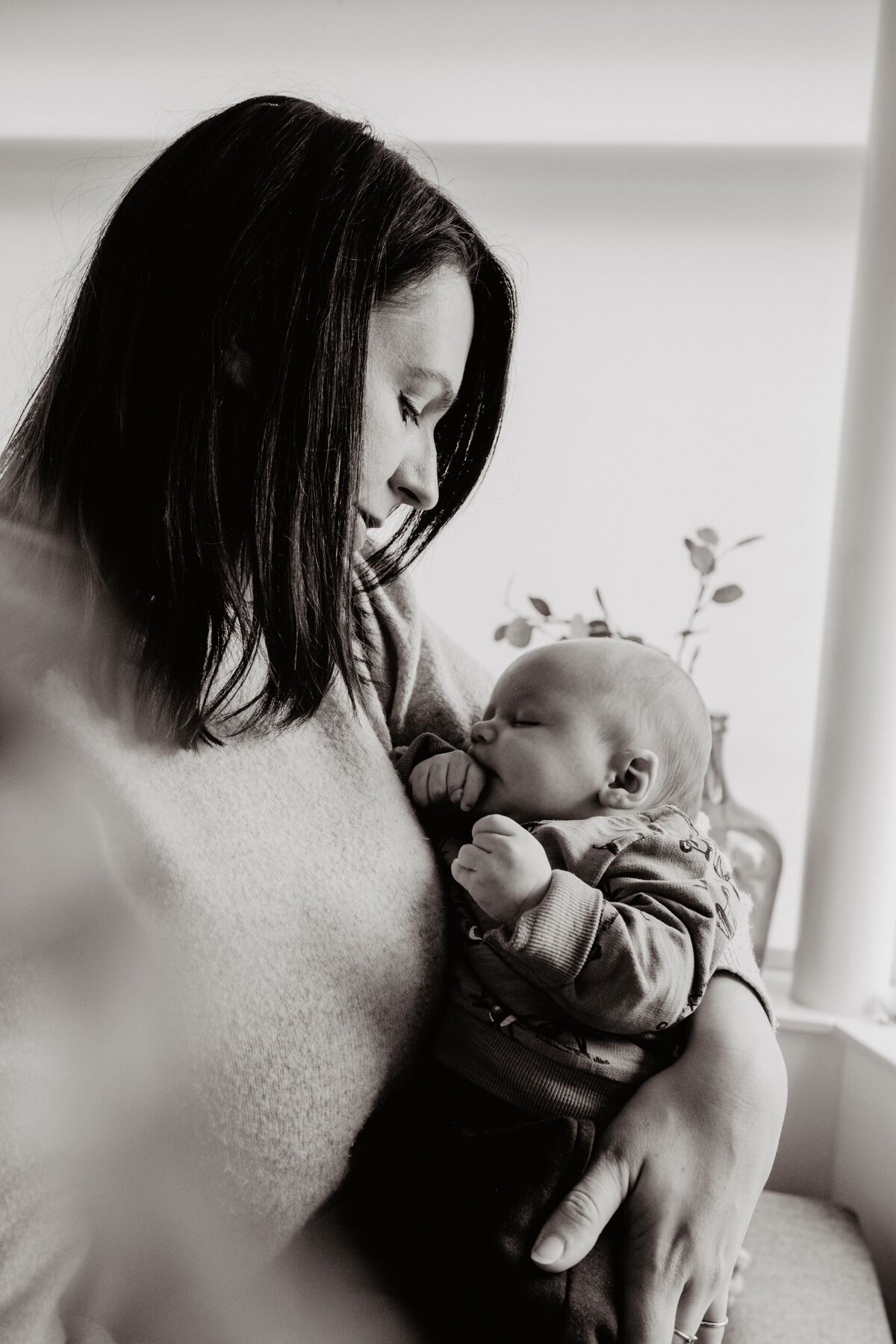 Foto van een pasgeboren baby en zijn moeder door een professionele fotografe