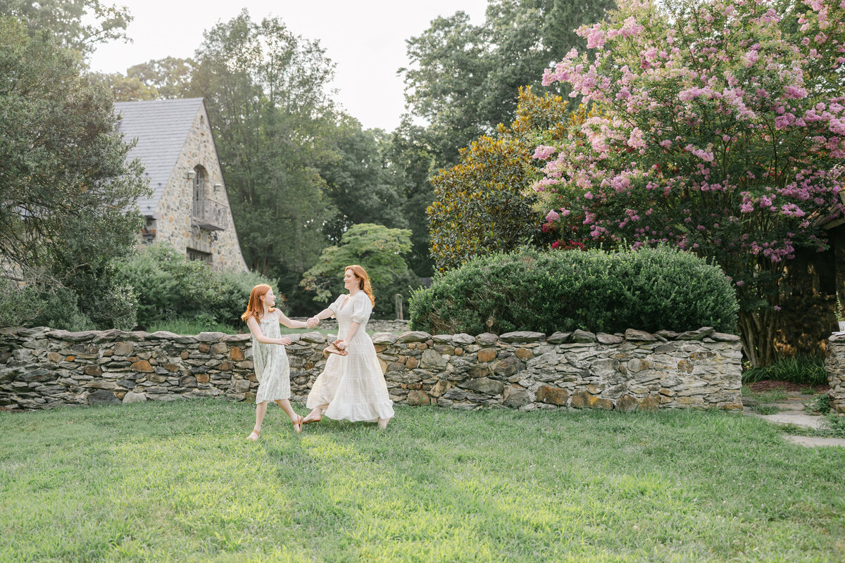 Little girl holding moms hand and crossing field