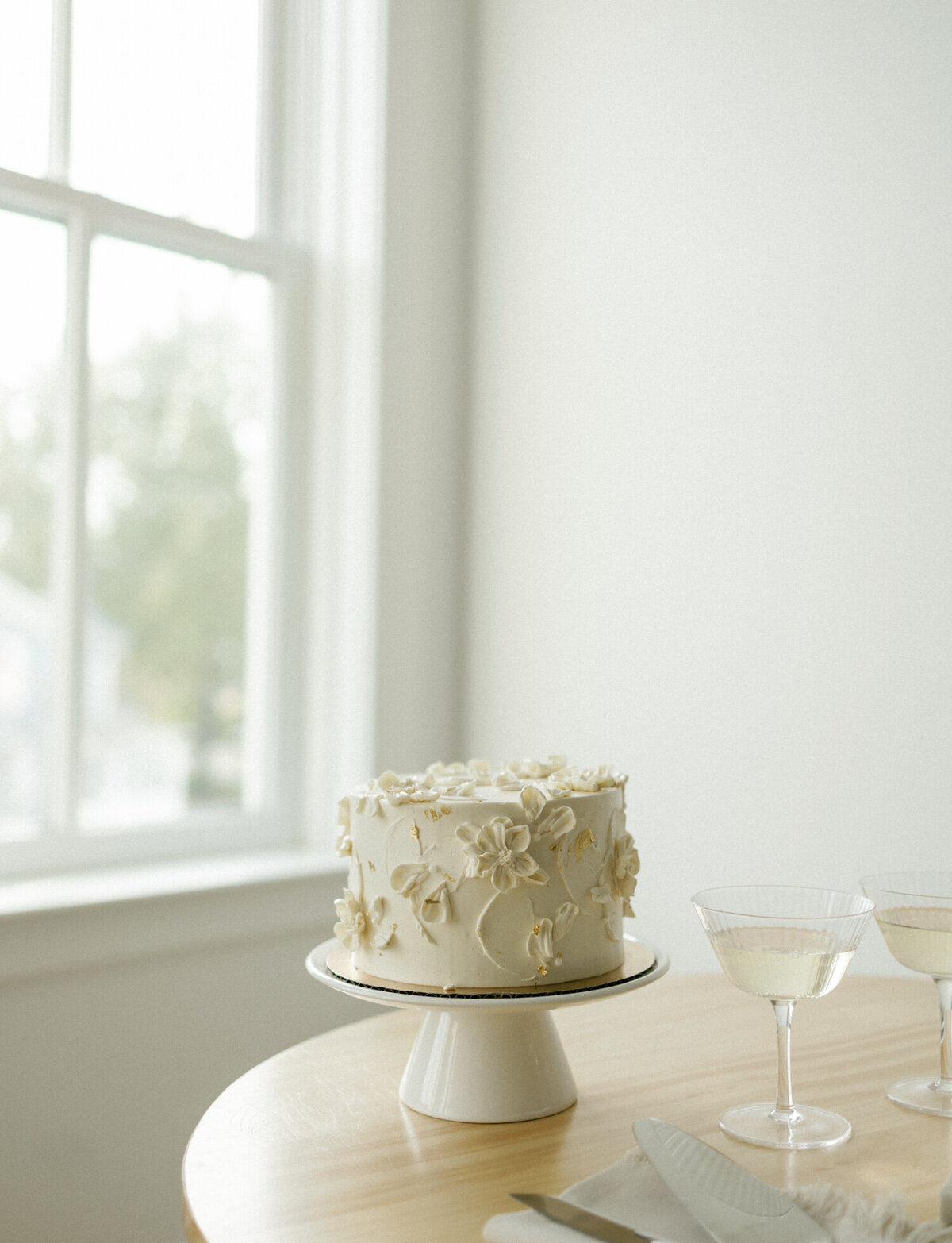 simple white wedding cake with frosting flowers, clean white photography studio space in Ohio