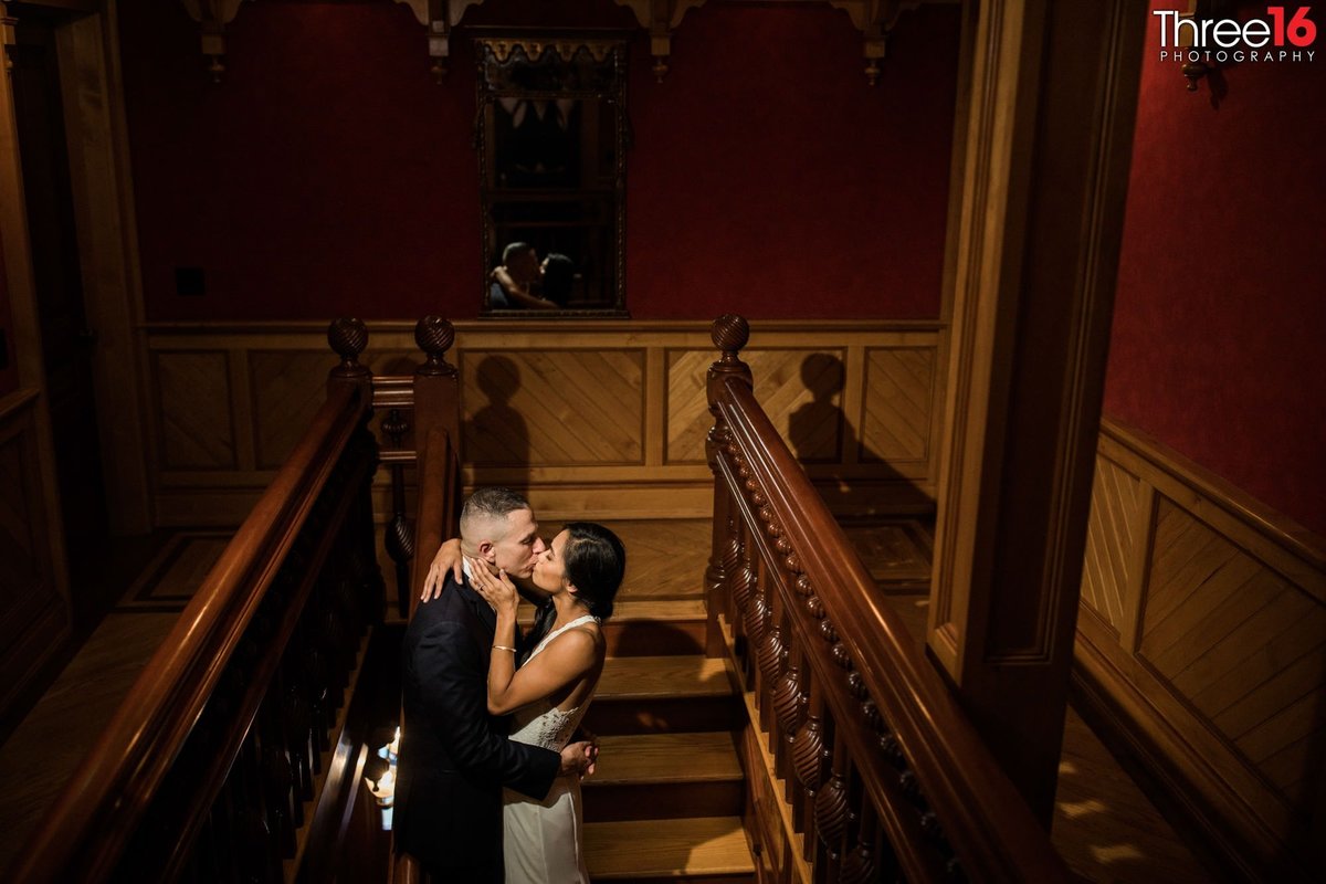 Bride and Groom share a kiss on the staircase