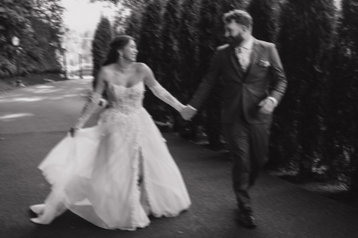 Bride and groom walk hand in hand during a quiet wedding moment.