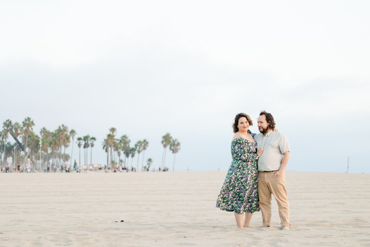 A couple standing close together on the beach