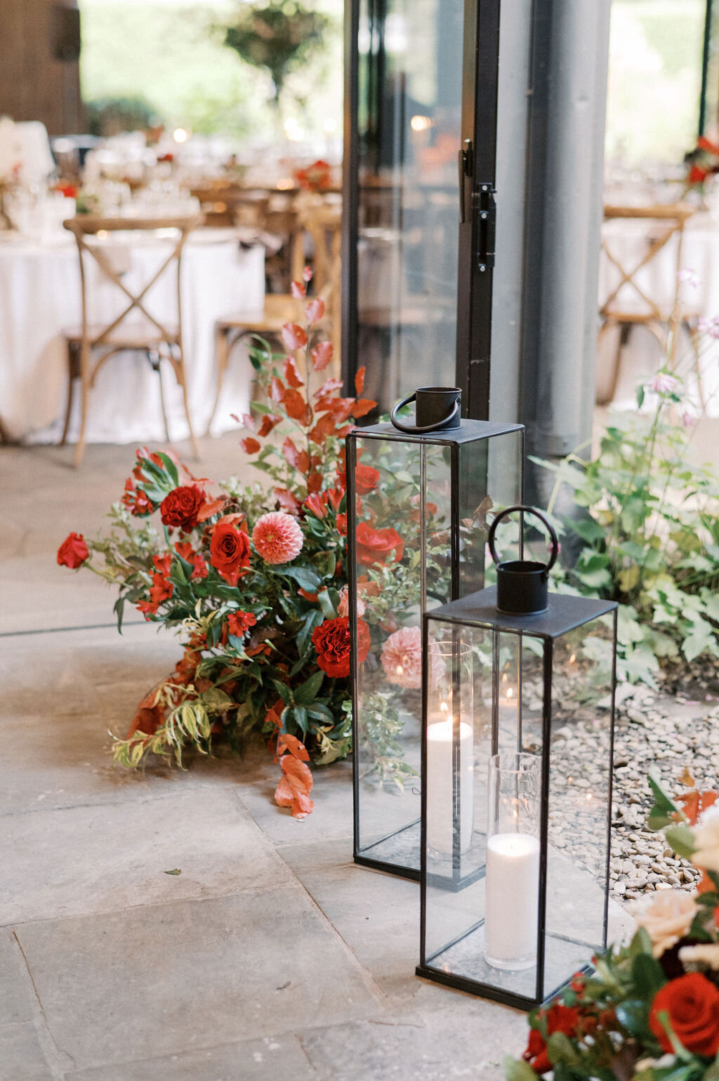 Red floral arrangements and lanterns at a luxury wedding reception in Highlands, NC. 