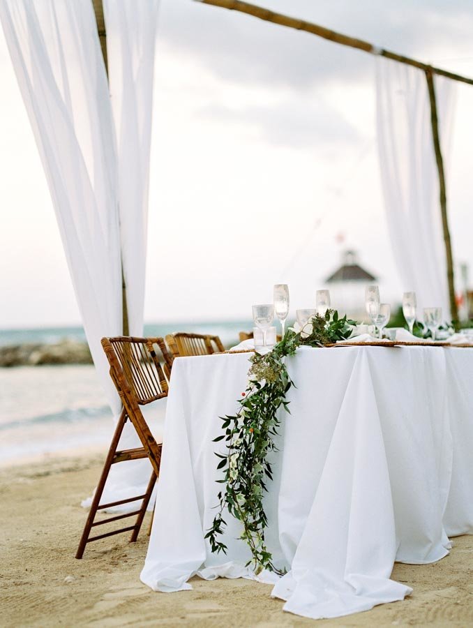 White Tablecloth Bamboo Folding Chairs Green Runner Beach Wedding Dinner © Bonnie Sen Photography