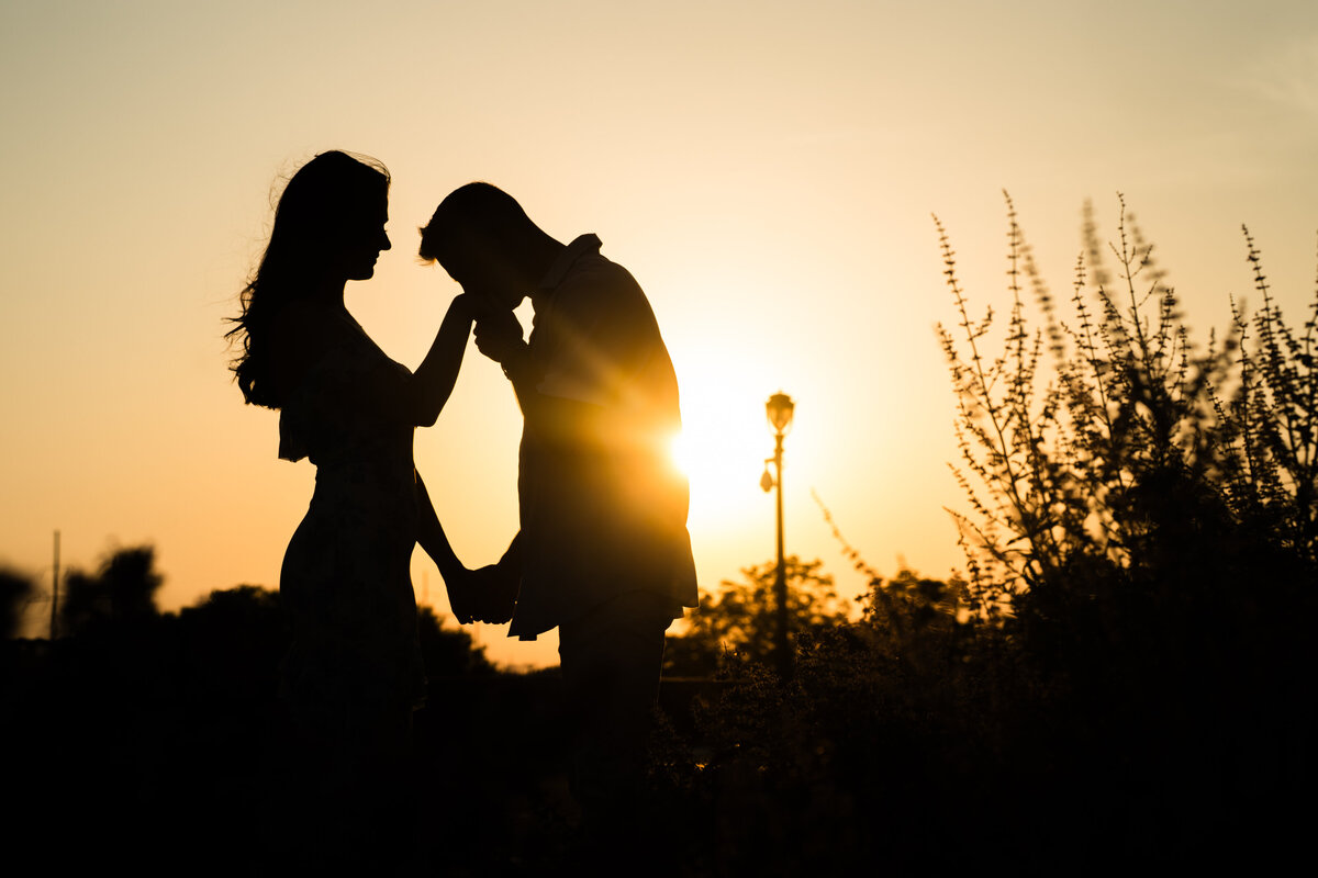 silhouette of an engaged couple with the sunset in the back 