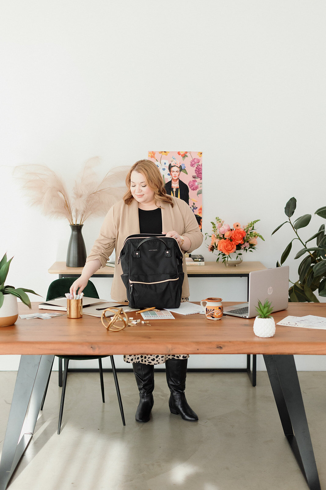 successful entrepreneur behind her desk and putting folders in her bag