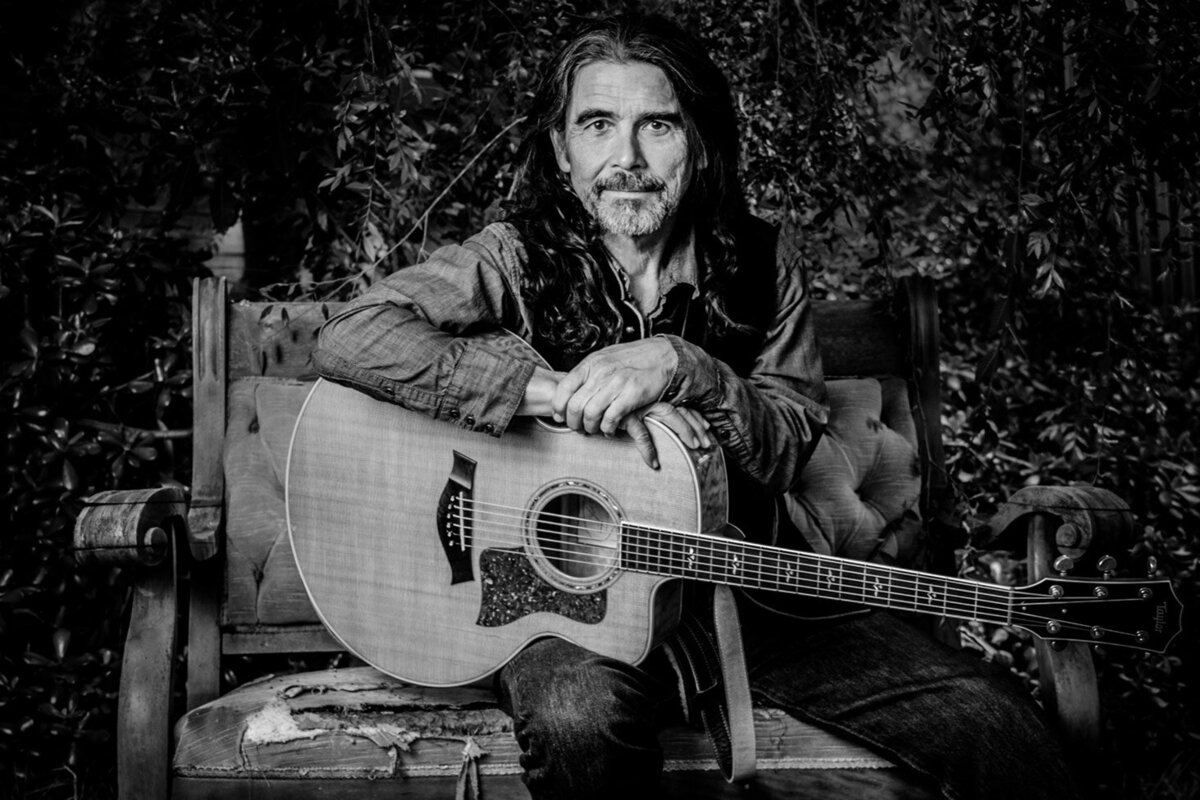 Country Music Artist portrait Jess Wayne sitting in old wood chair with acoustic guitar on his lap black and white