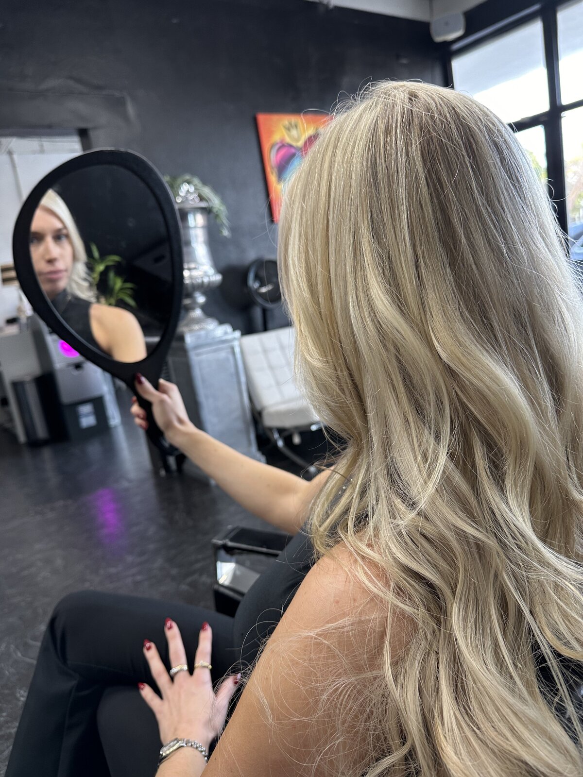 Woman with blonde hair looking in mirror