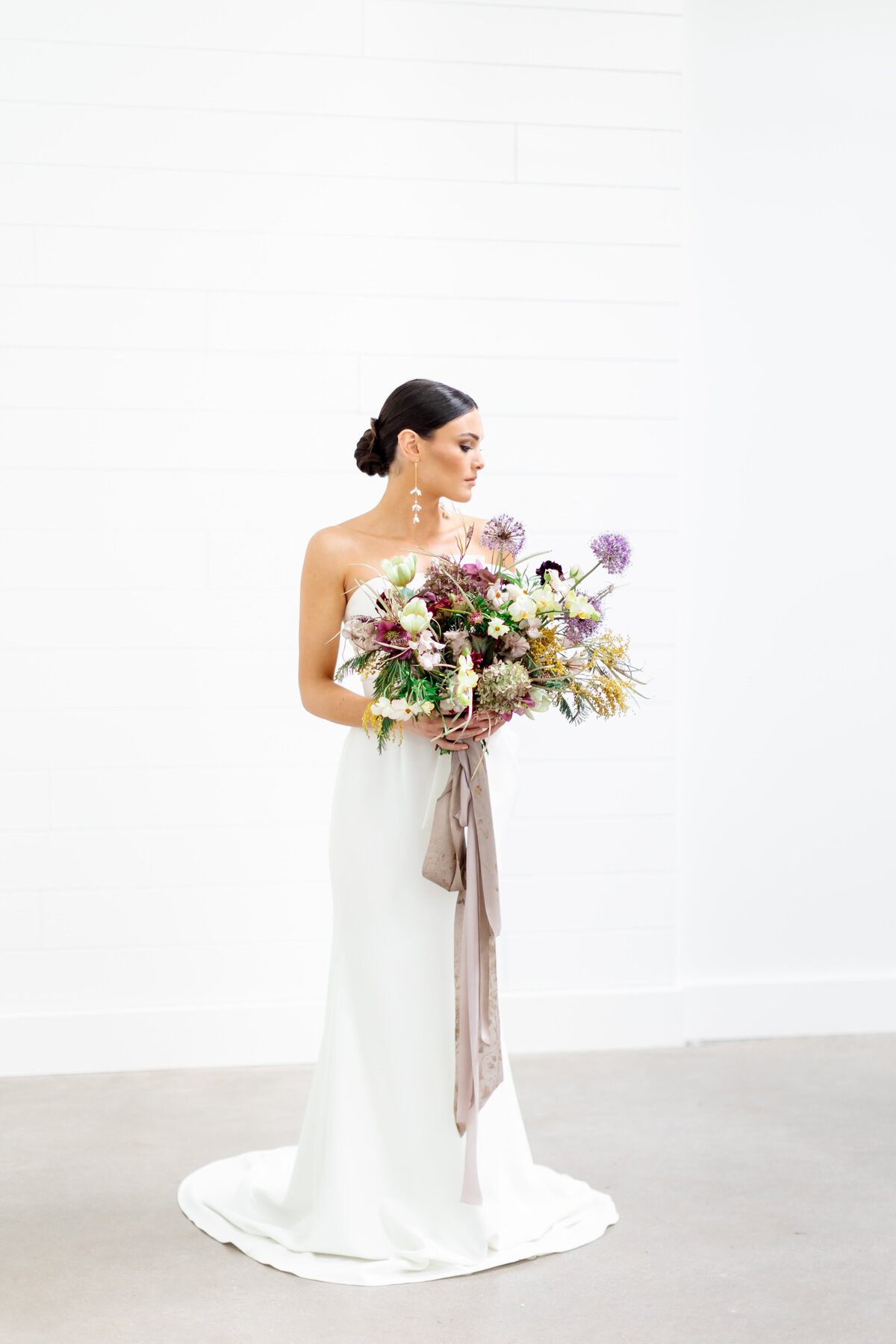 bride looking at wedding floral bouquet by wedding photographers sarasota