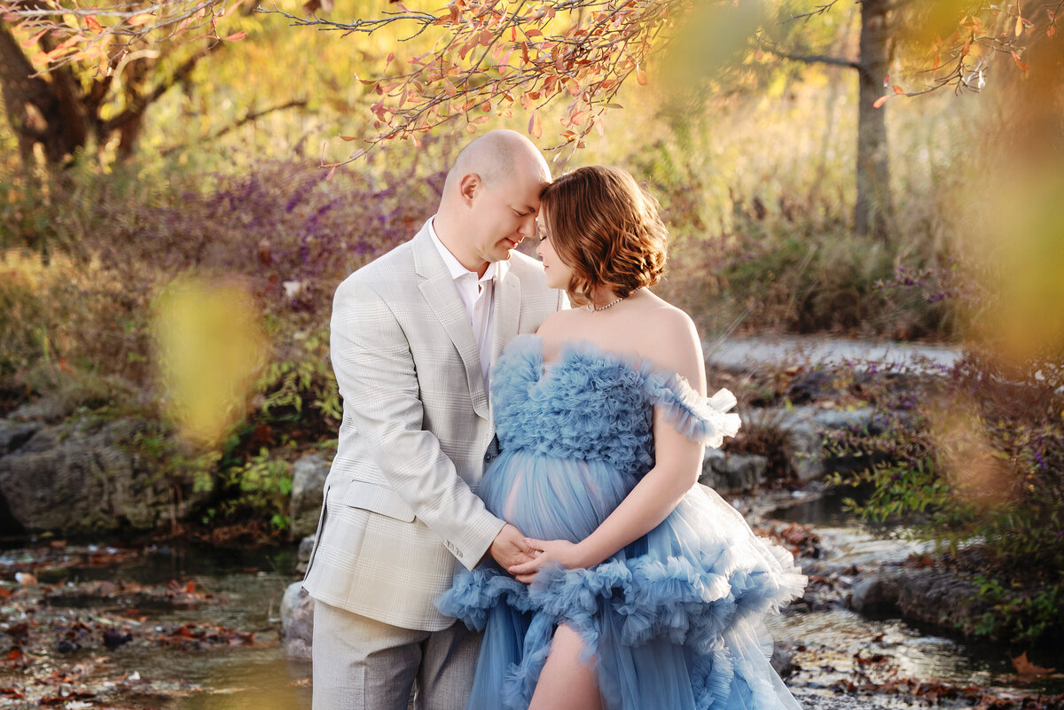 st-louis-maternity-photographer-pregnant-mom-in-blue-tulle-gown-with-dad-in-gray-suit-at-st-louis-forest-park-in-the-fall