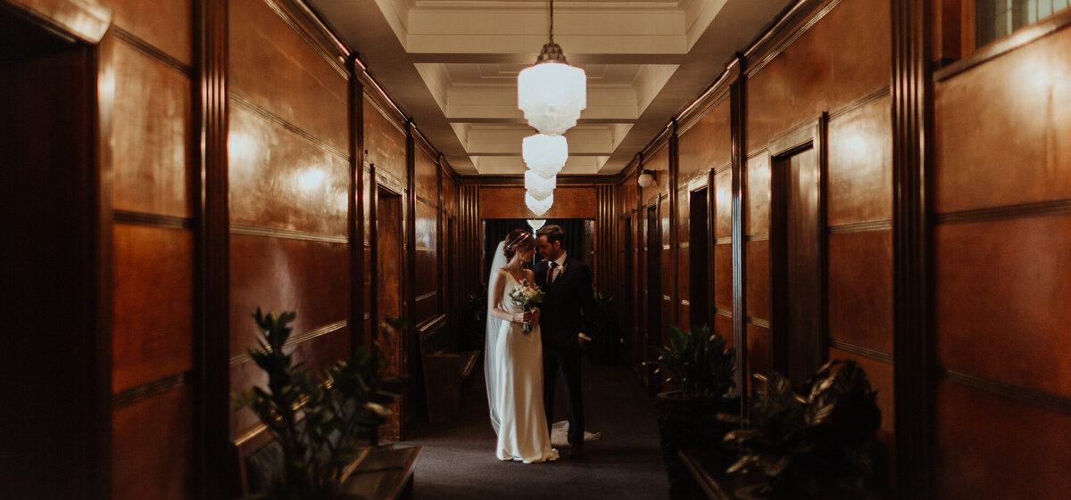 bride and groom in a long hallway