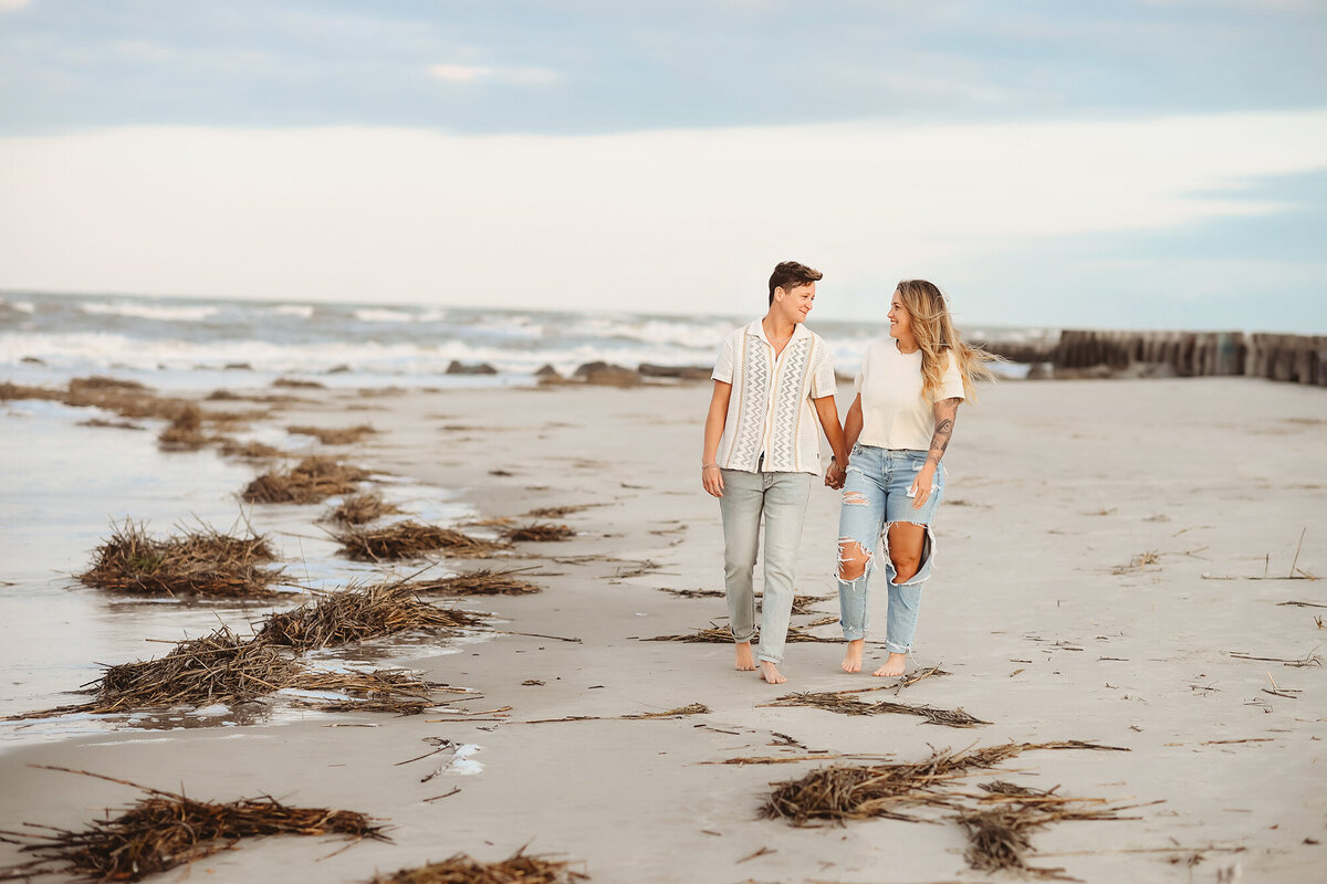 LGBTQ Friendly Photographer in Charleston, South Carolina. Same Sex couple walks hand in hand for portraits on Folly Beach.