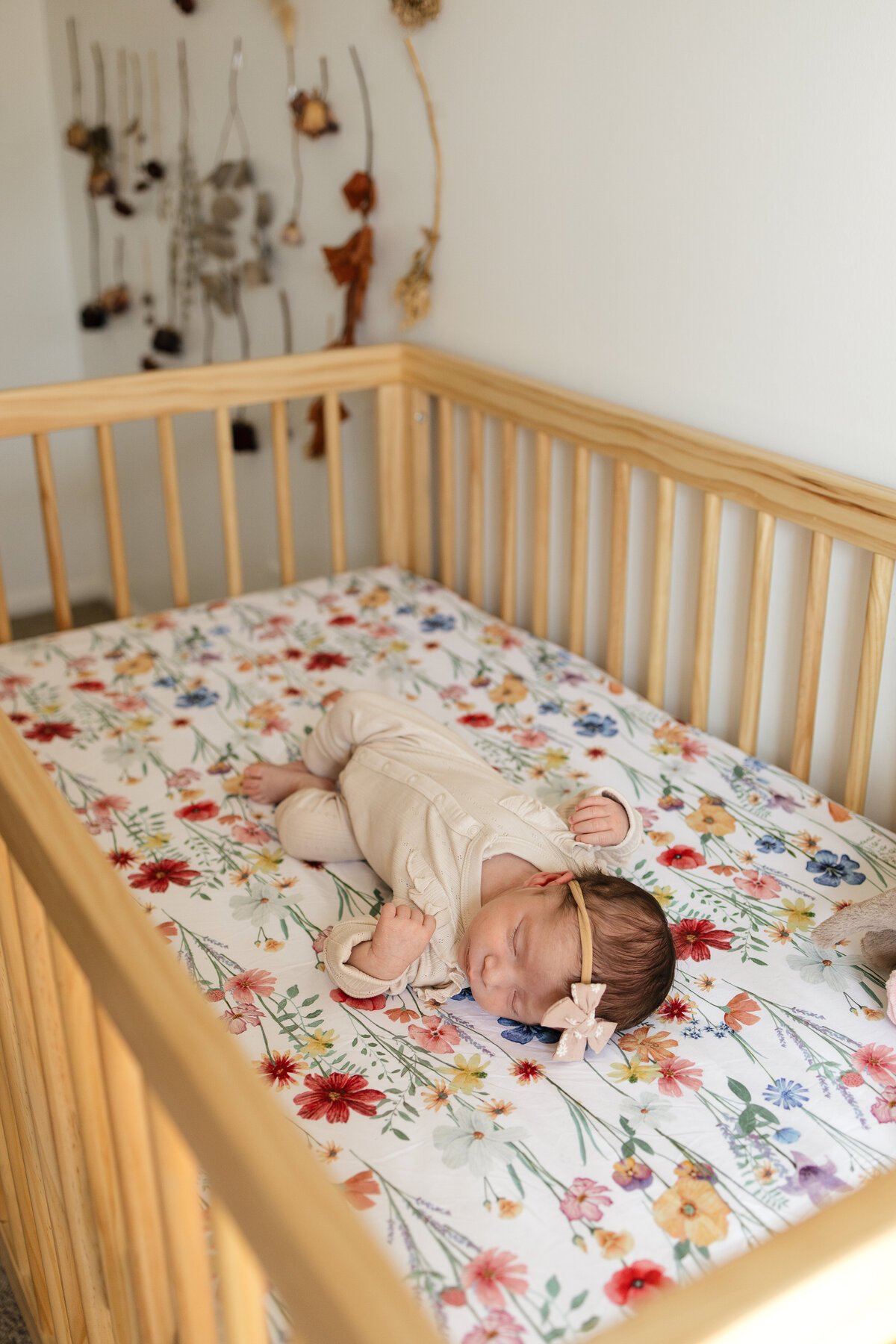 Longmont colorado newborn baby girl laying in crib during in home newborn session with alexis adkins photo