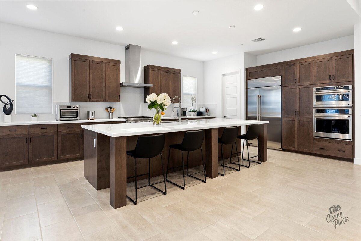Modern and bright kitchen with dark wood cabinets and white countertops.