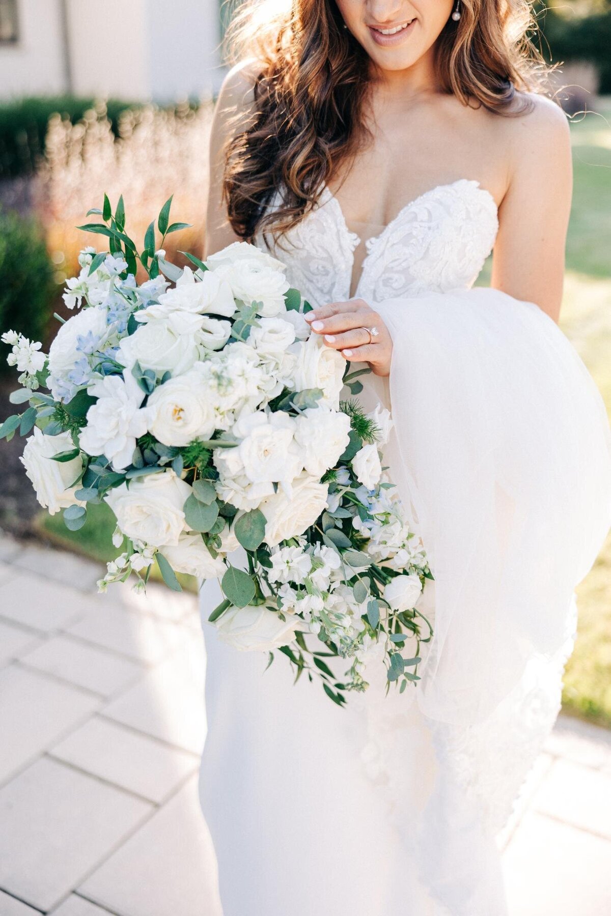Bride holding a bouquet of white flowers.