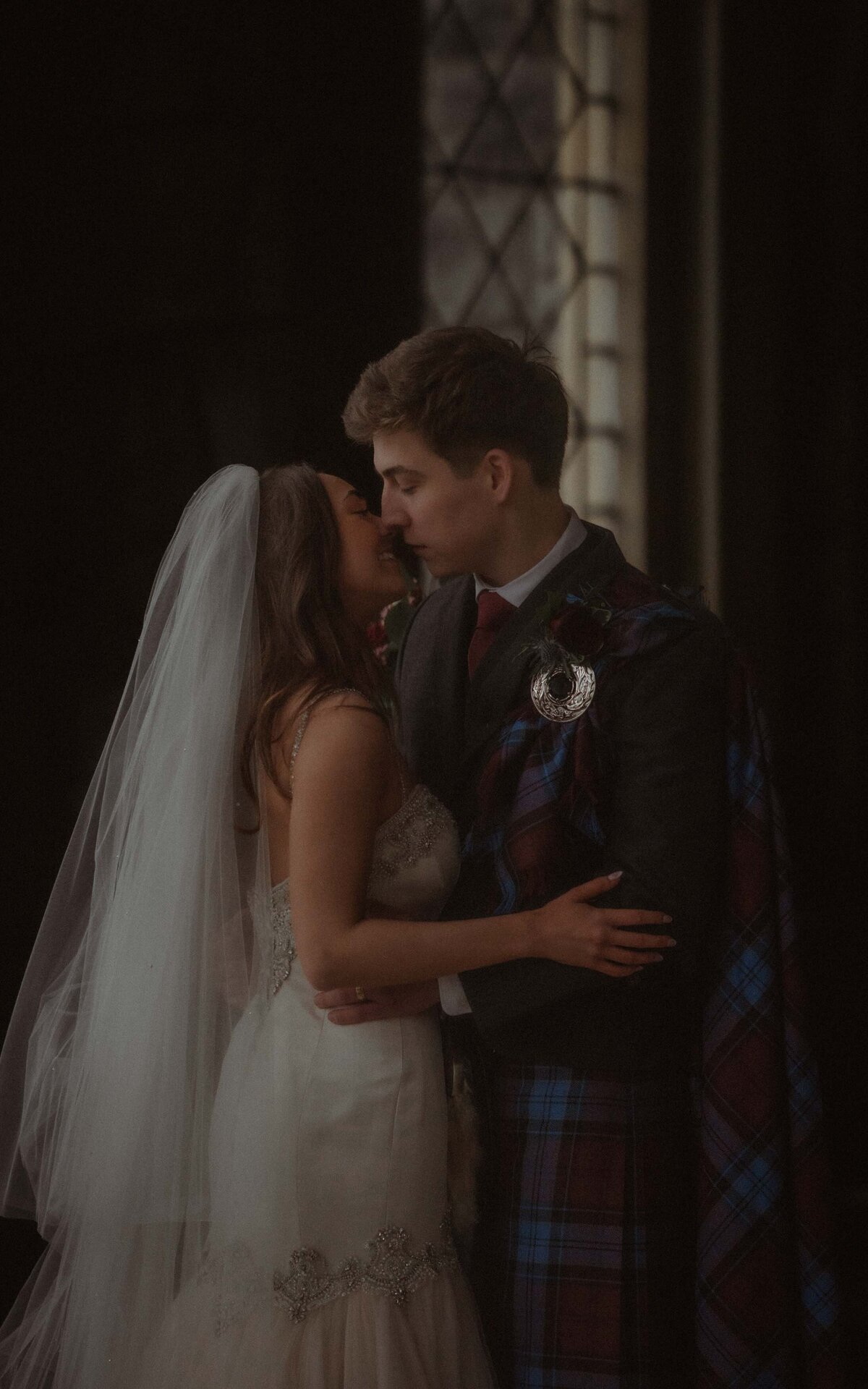 Capturing the intimate and timeless moment of a couple's kiss during their wedding photoshoot, highlighting love and connection in a beautifully romantic setting
