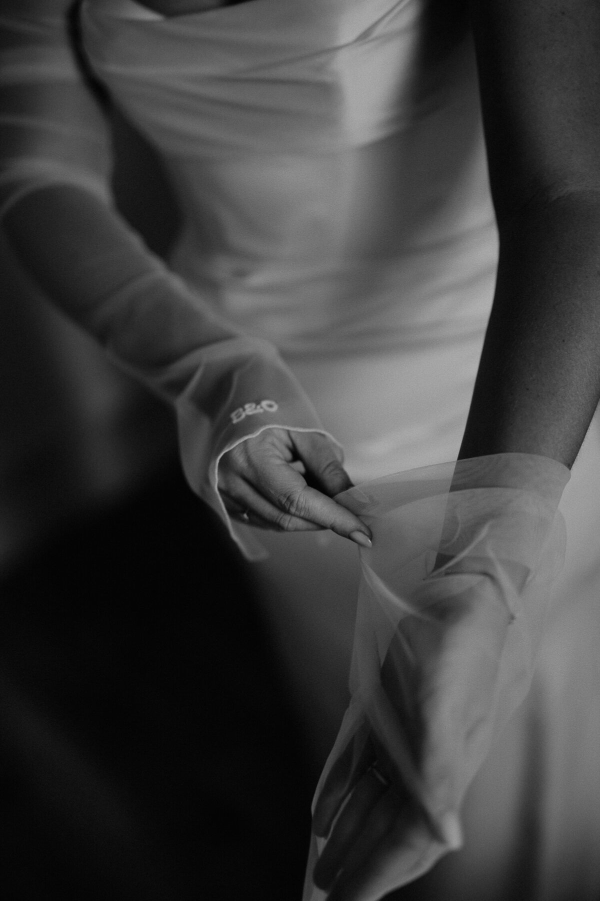 Bride putting on sleeves before her wedding at The Shack Revolution. 