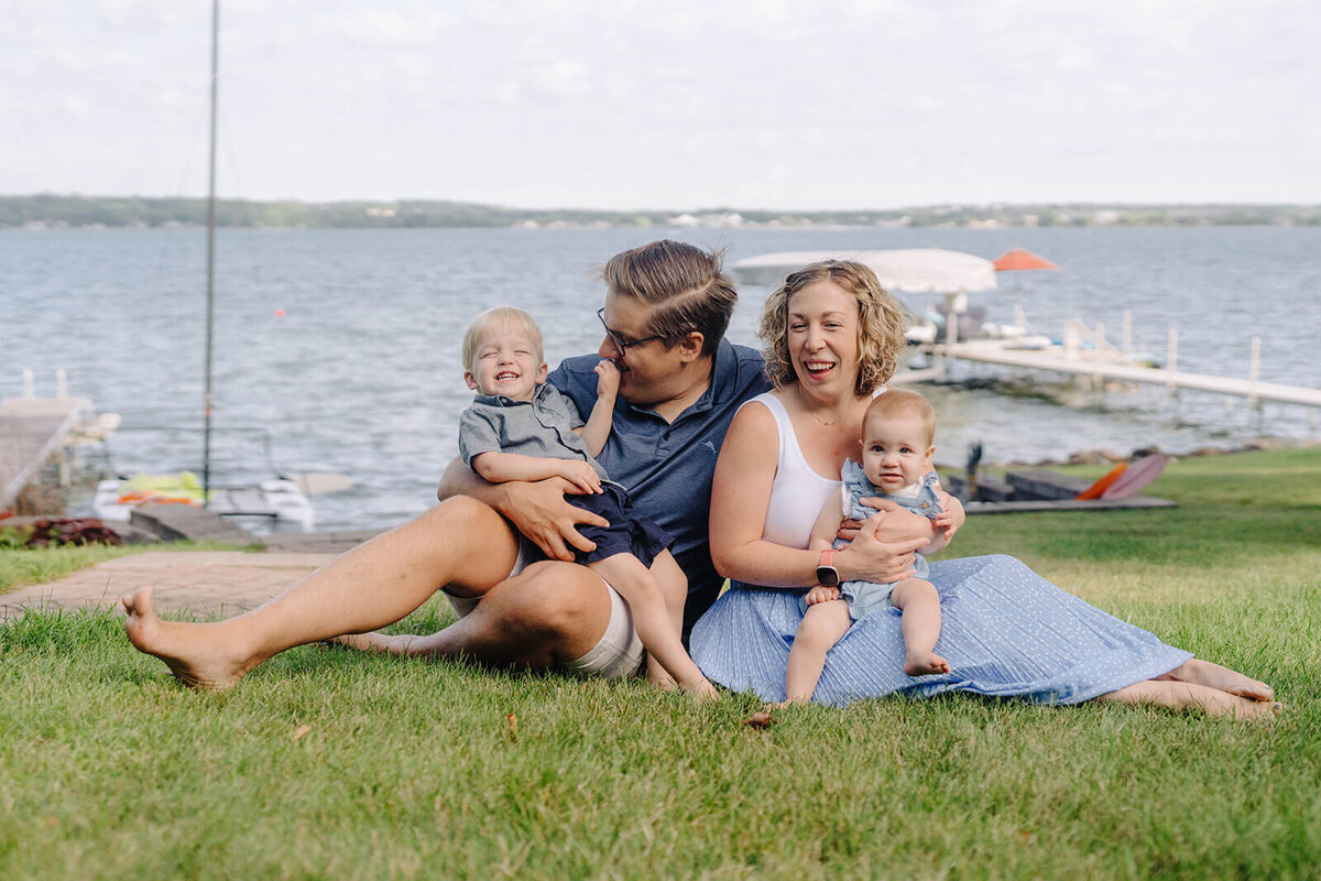 Family sitting on grass with kids at generational photoshoot in Finger Lakes, NY