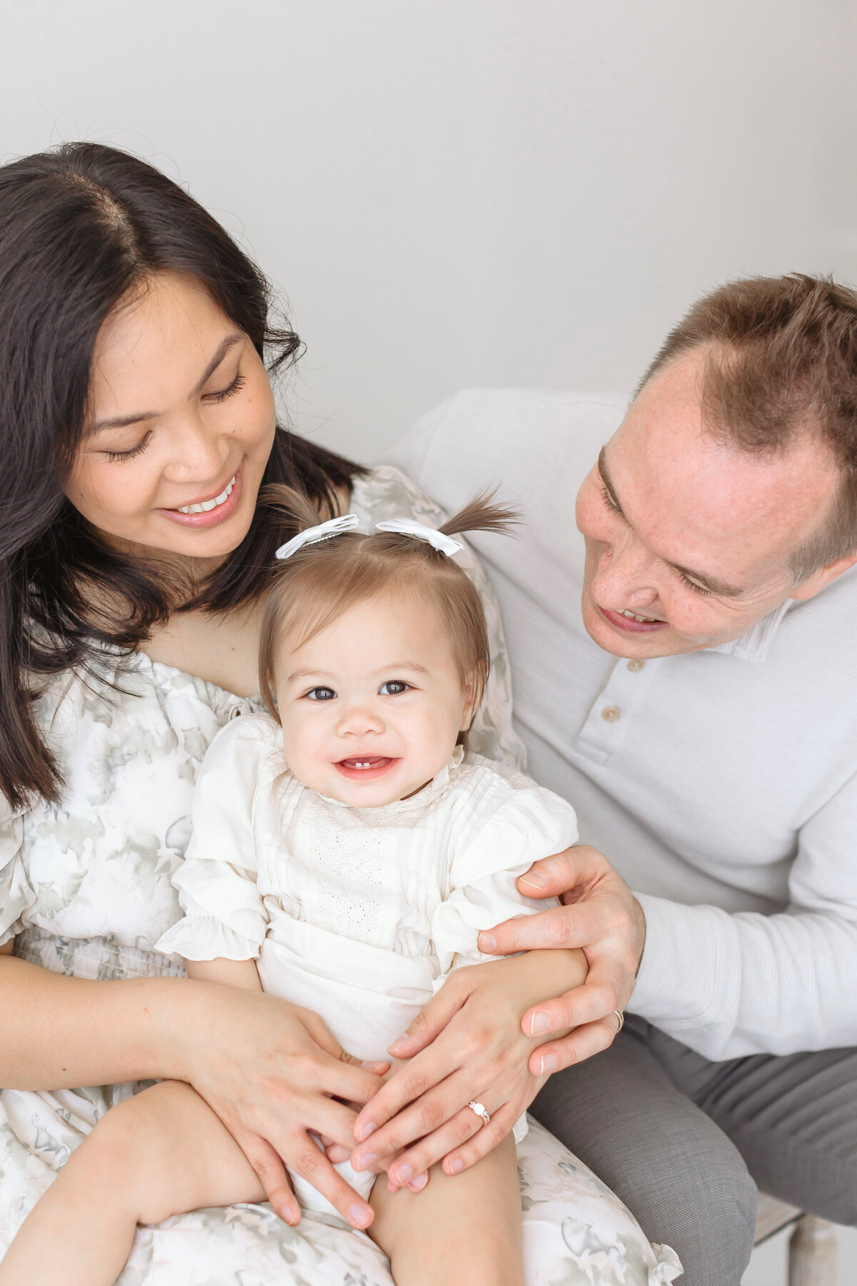 parents sitting and holding toddler girl