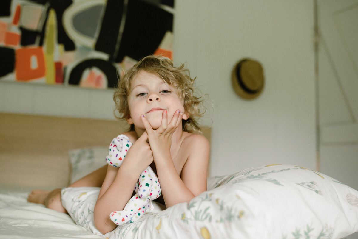 Toddler boy lying on bed at Austin family photo session