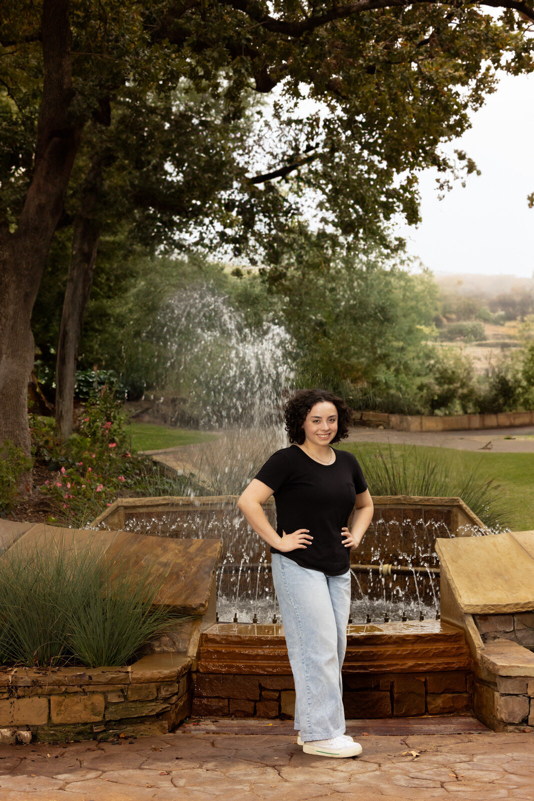 senior-girl-posing-by-fountain-grapevine-botanical-gardens