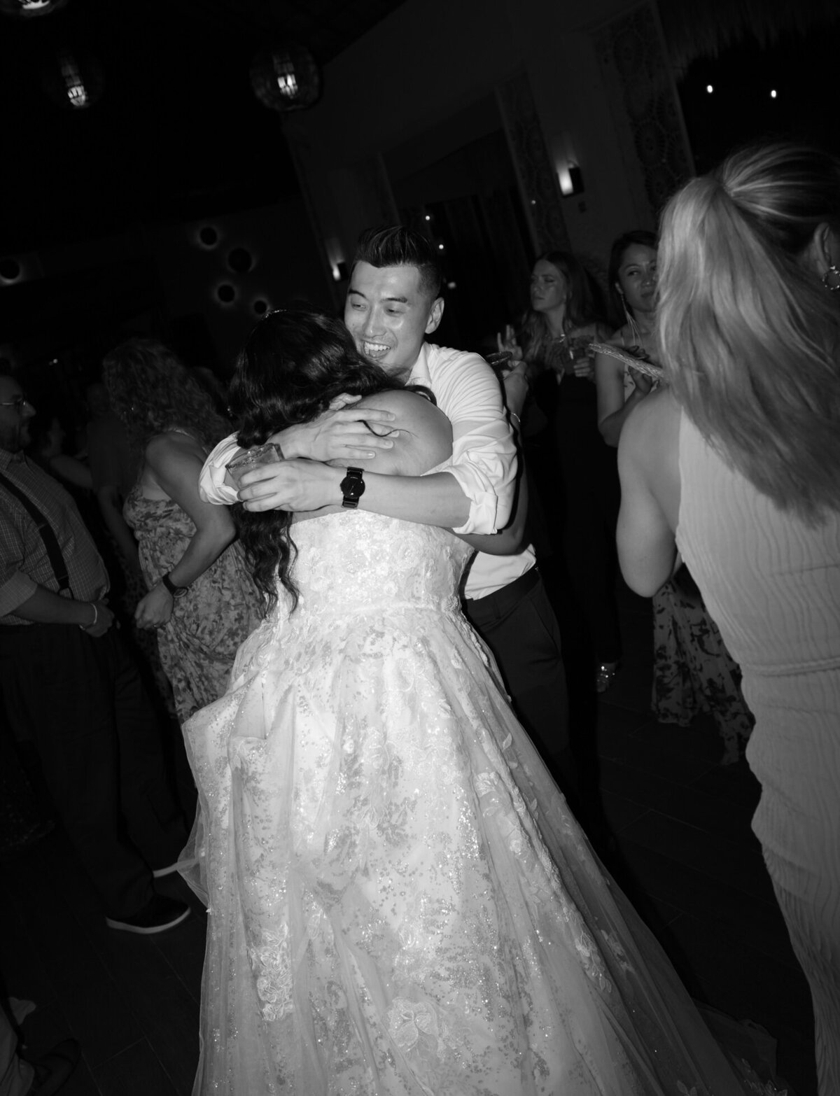 wedding guest hugs bride on dance floor, Paradisus playa del Carmen wedding reception