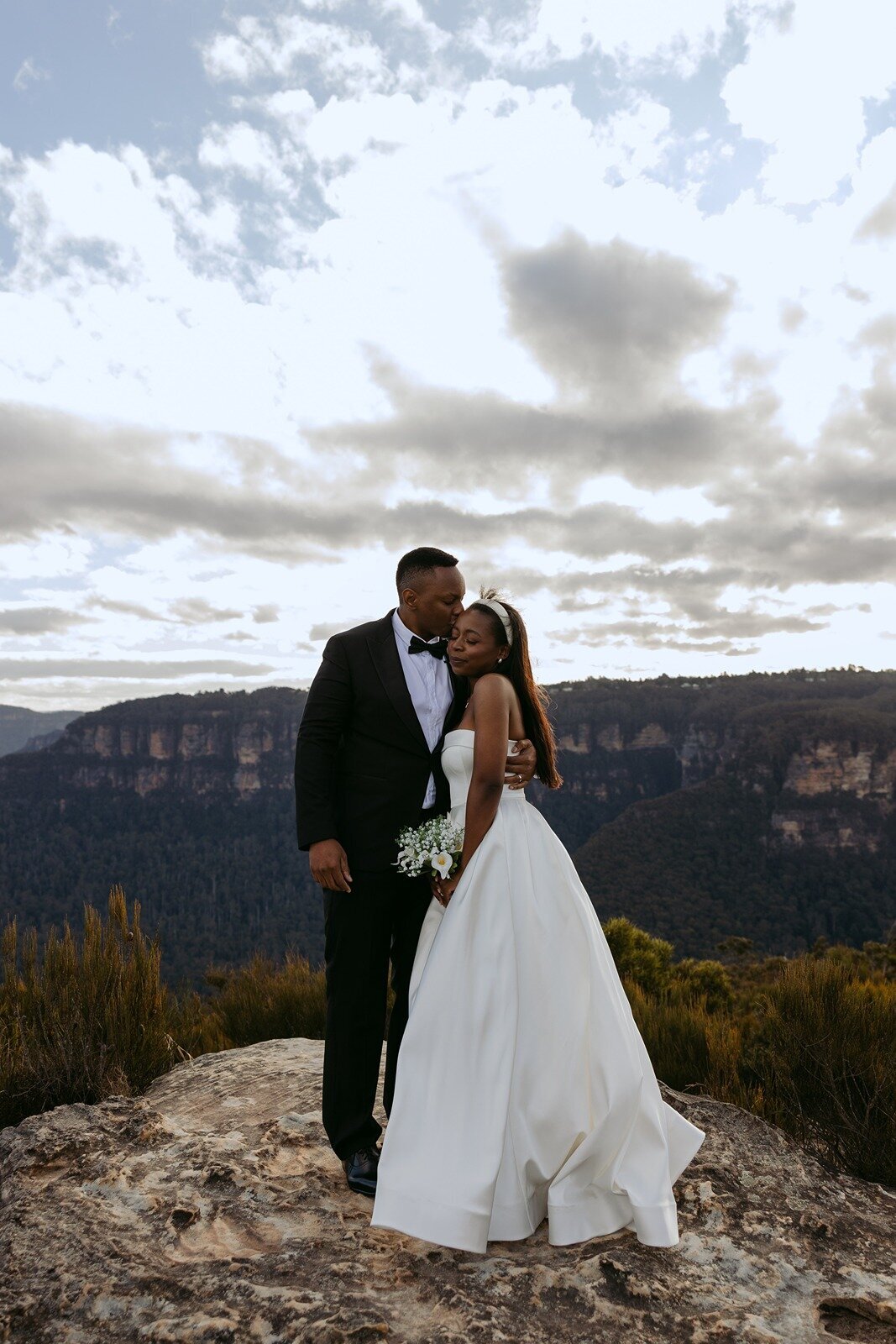 A bride and groom standing on a cliff getting married in the blue mountains NSW