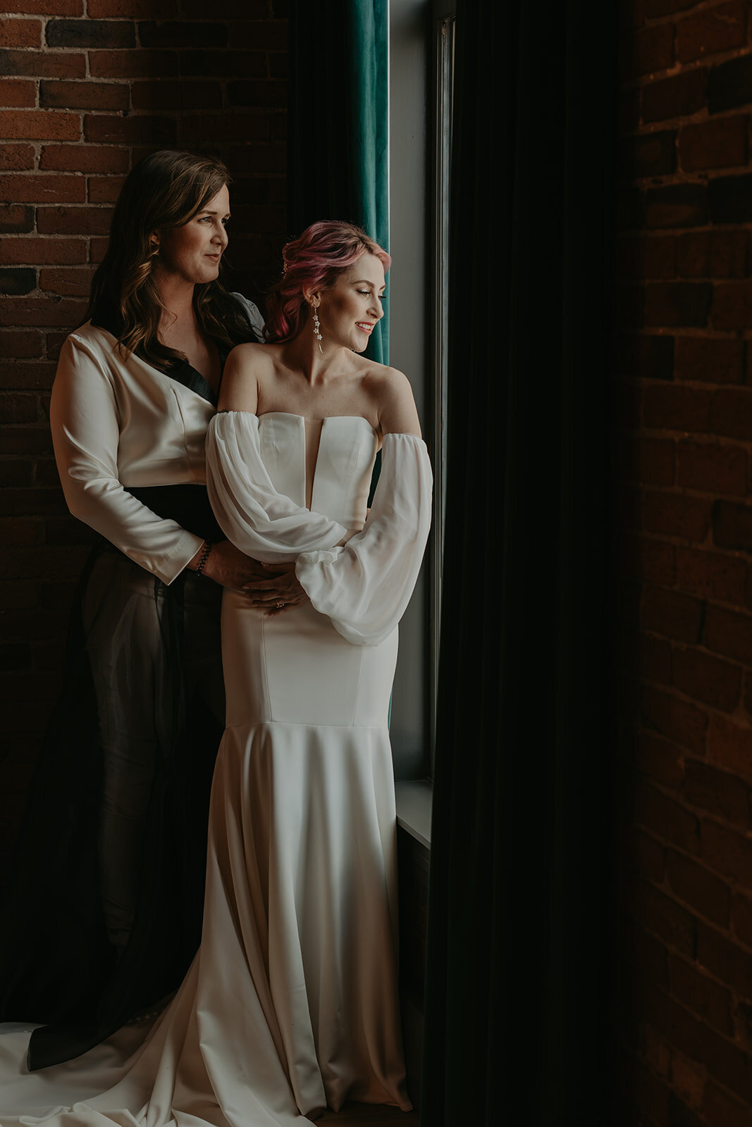 couple standing by window before wedding day