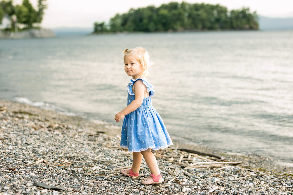 Two year old walking on the shore of Lake Champlain by Vermont Family Photographer