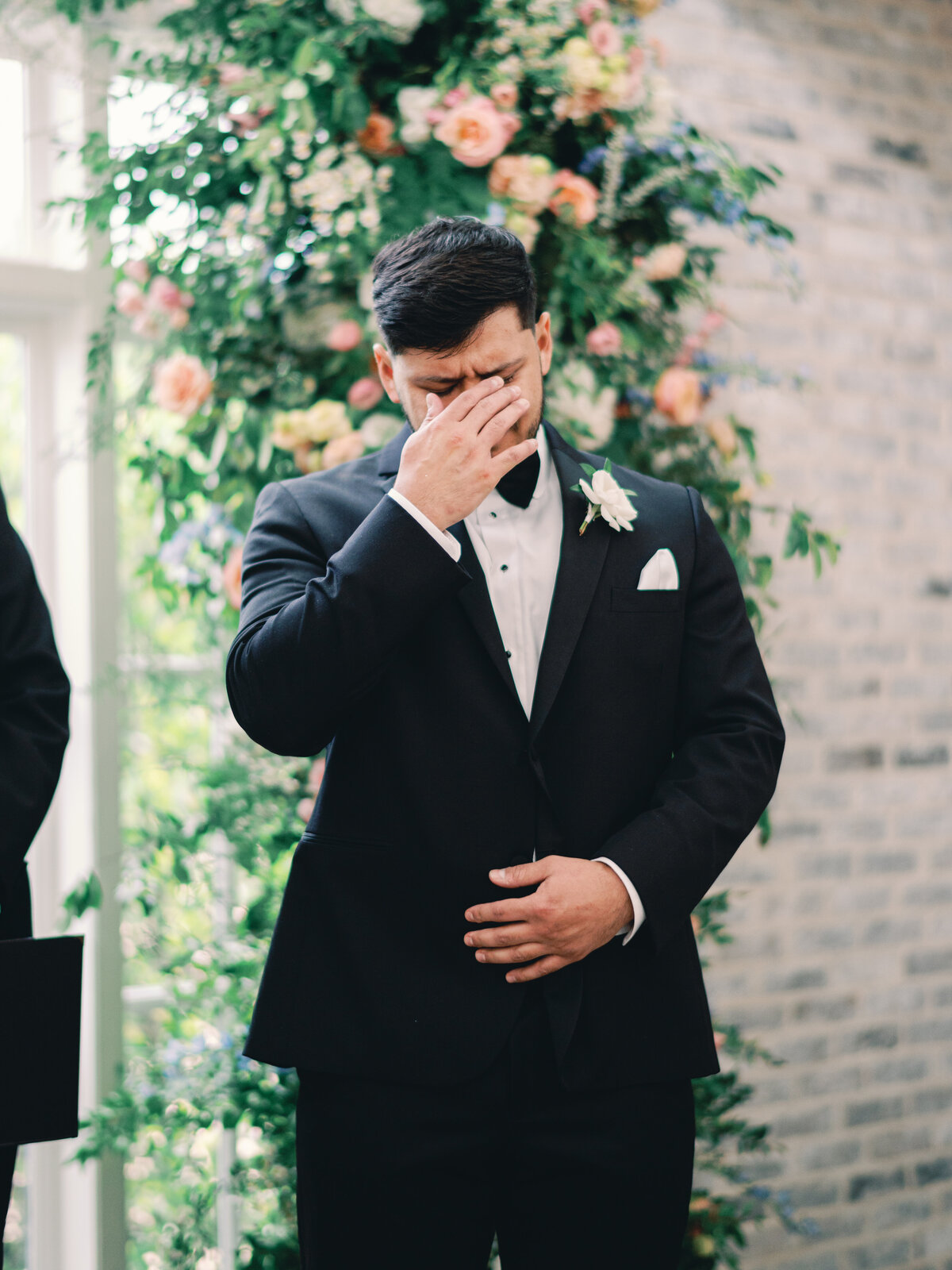 groom crying at altar watching his bride walk down aisle during wedding ceremony