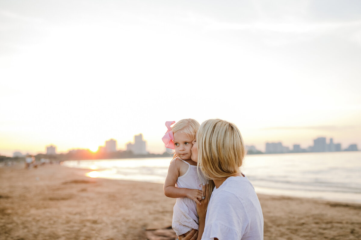 chicago-lifestyle-family-photographer-mom-kissing-daughter-love-beach-skyline