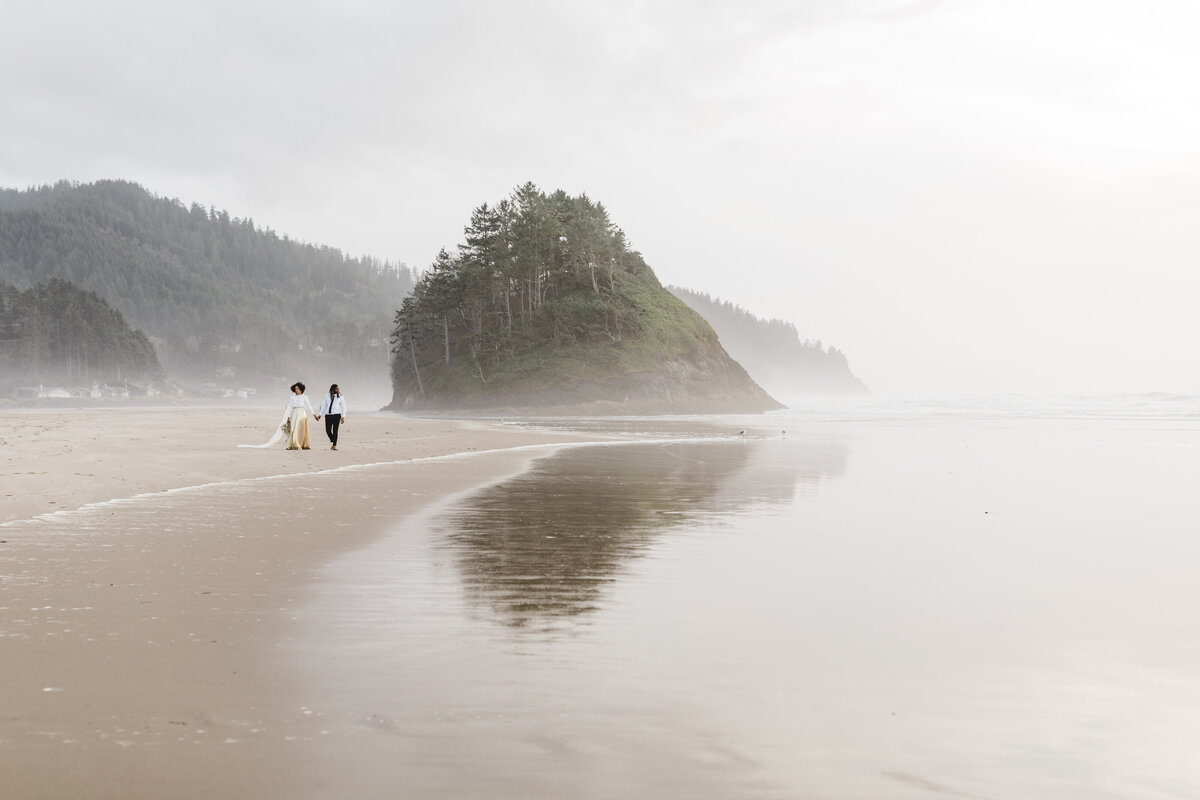 A bride and groom walk along Neskowin Beach during their Oregon Coast elopement. 