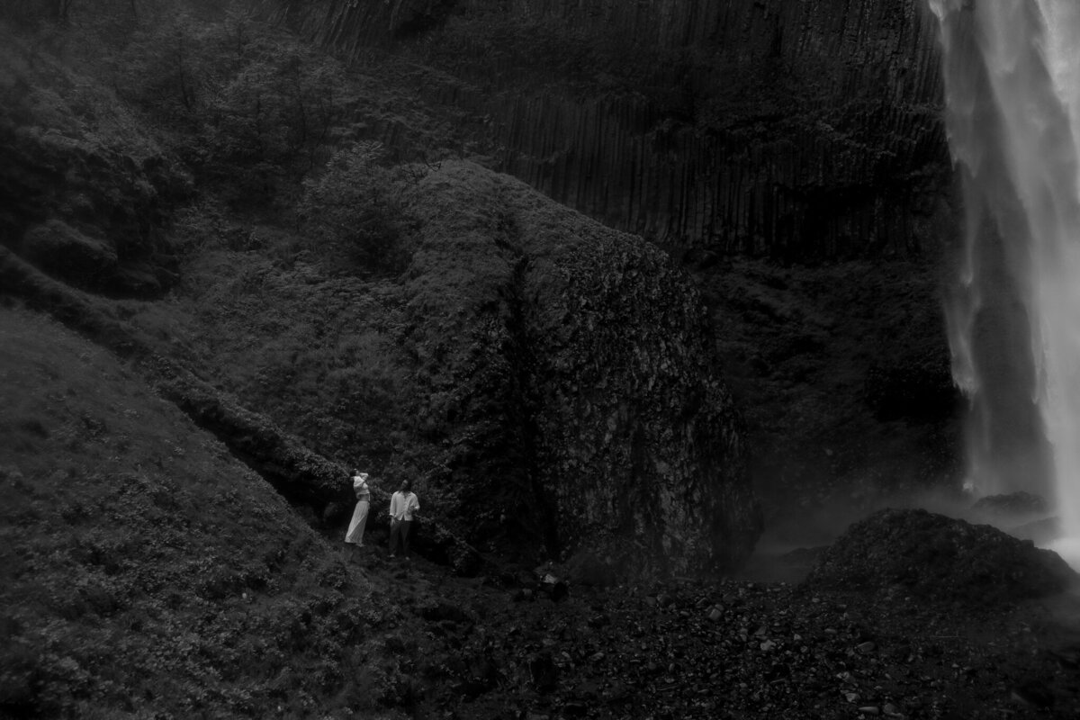 couples standing near waterfall