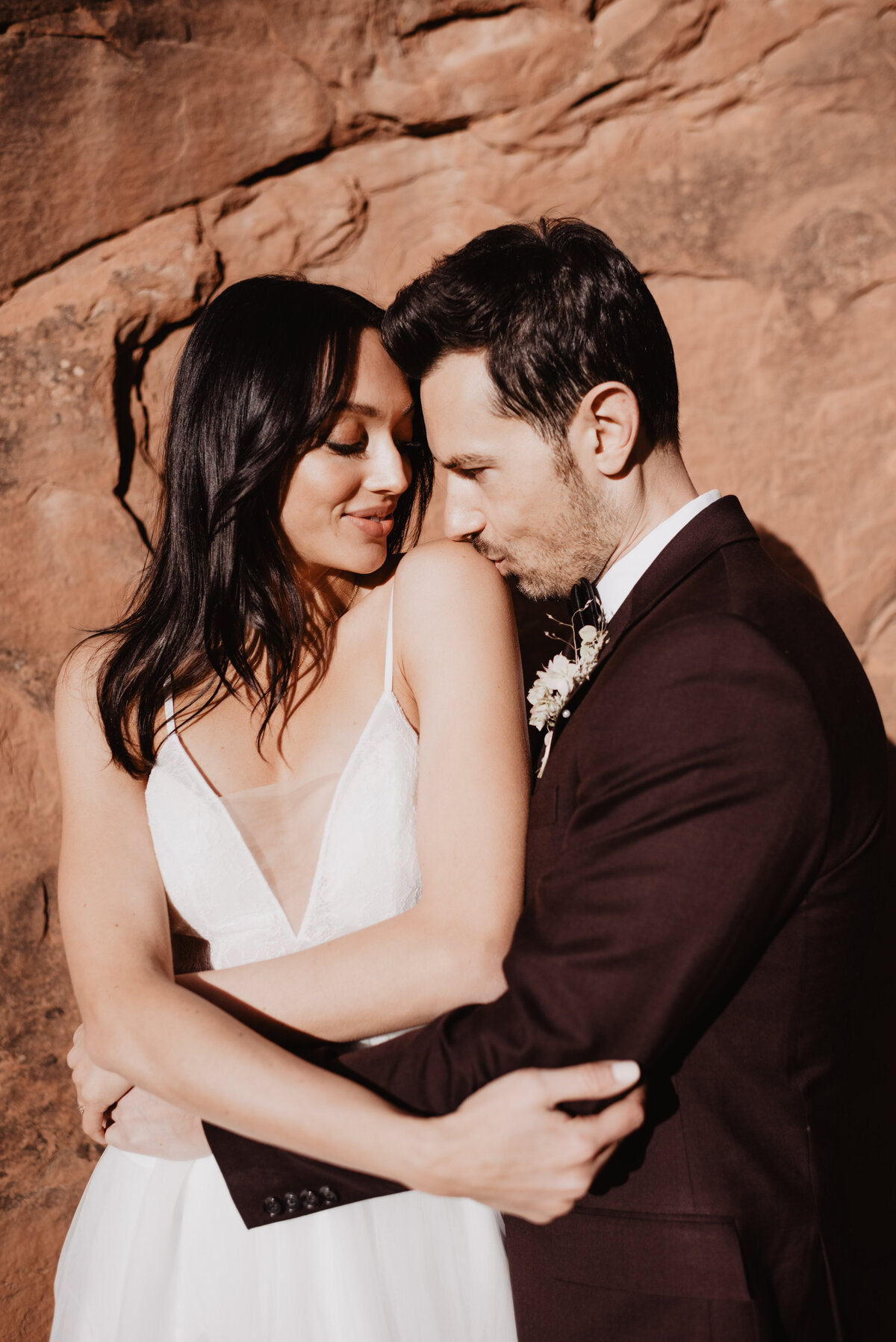 Utah elopement photographer captures groom kissing woman's shoulder