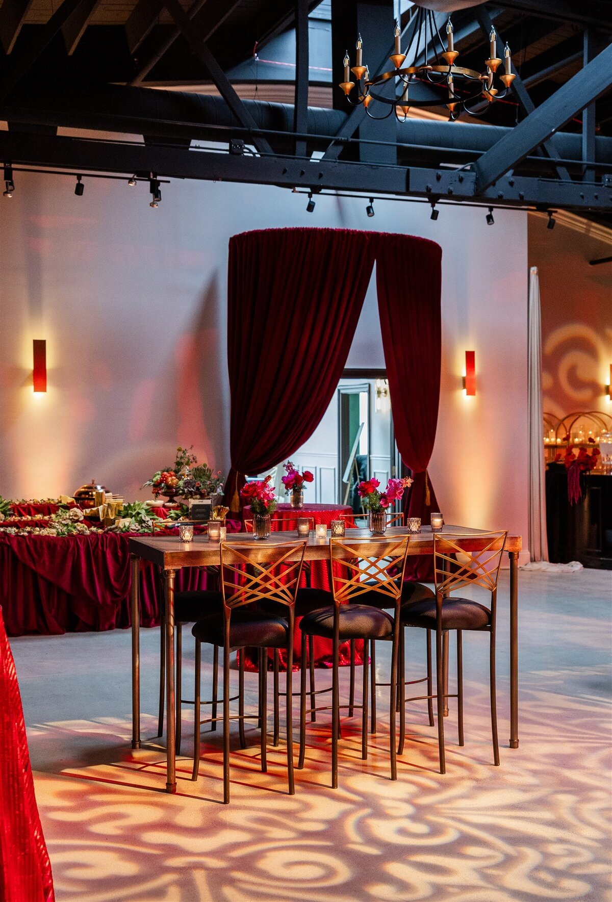 Event space styled with a Baroque theme, featuring ornate gold accents, rich fabrics, grand chandeliers, and intricate moldings, creating a luxurious and dramatic atmosphere