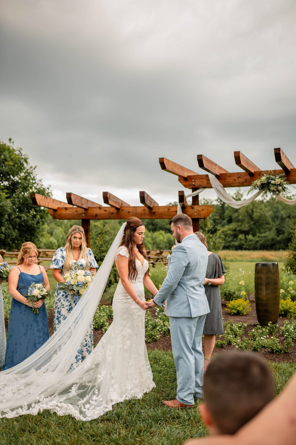 Couple holding hands during wedding ceremony under the pergola