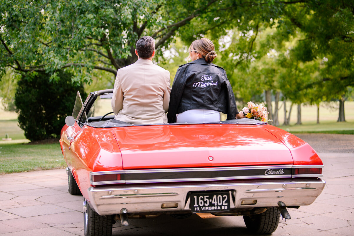 Bride and Groom kissing on convertible