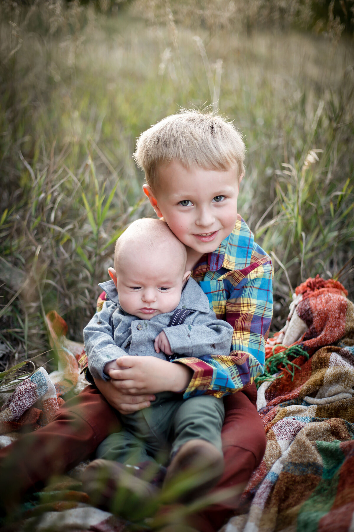 Big brother holds newborn brother