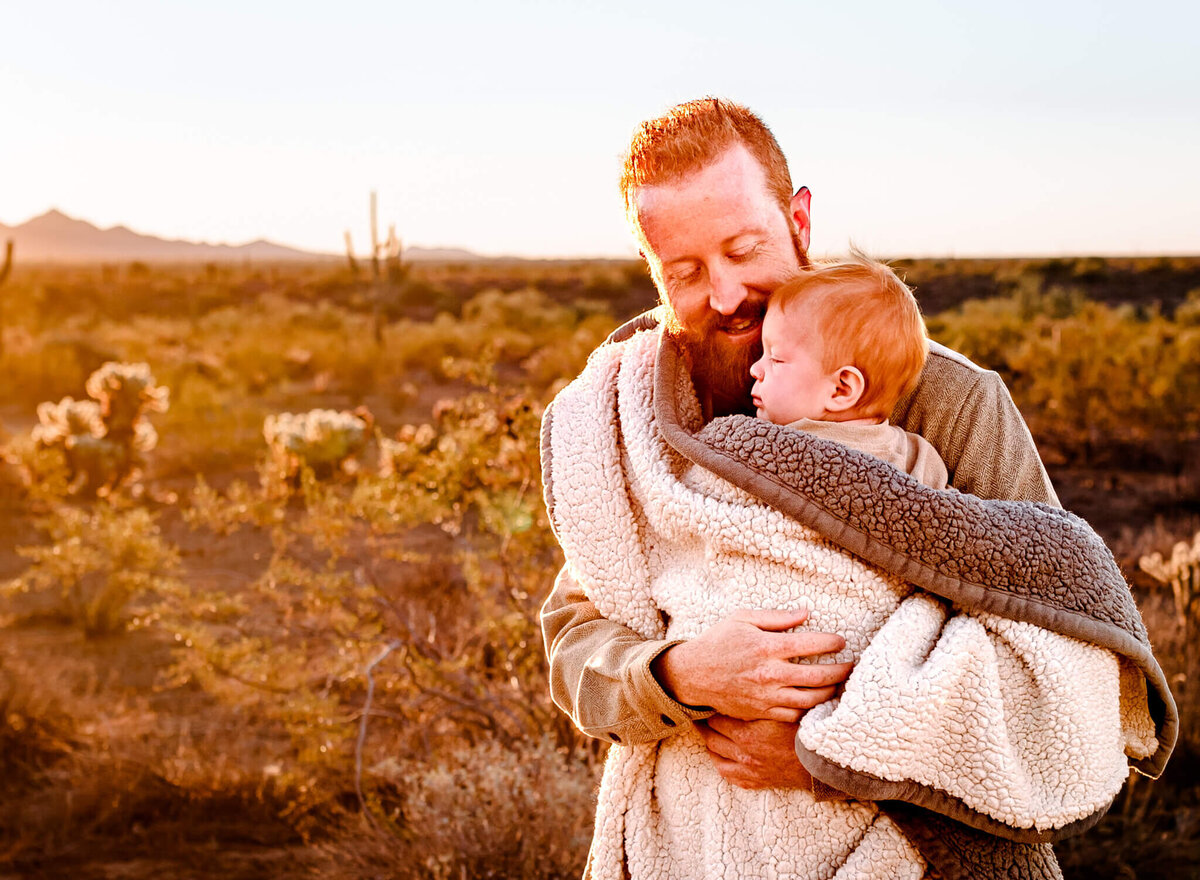 dad keeping son warm during family photography in Arizona winter