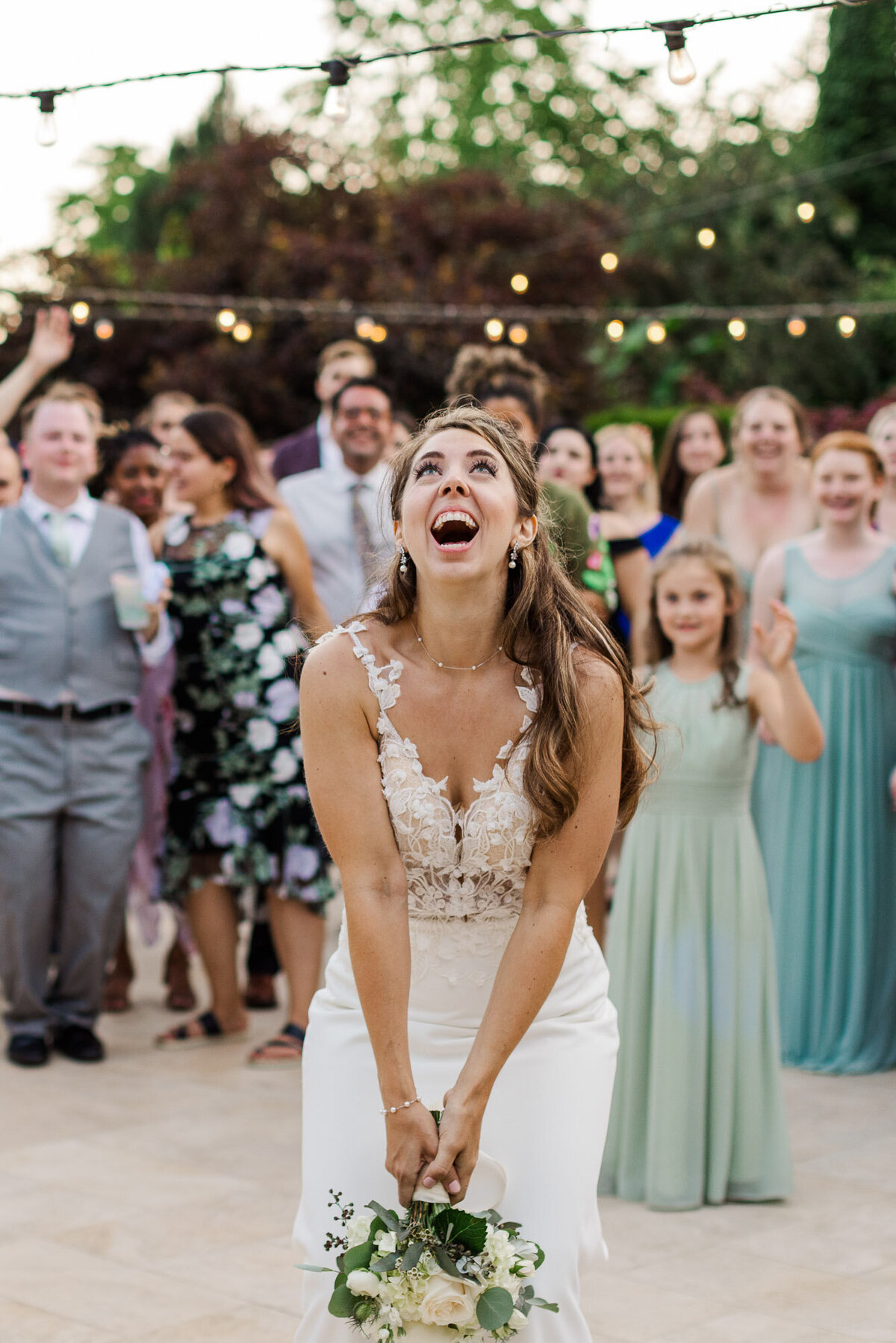 Bride-throws-flower-bouquet-at-fun-wedding-reception-at-Froggsong-venue-at-Vashon-Island-WA-near-Seattle-photo-by-Joanna-Monger-Photography